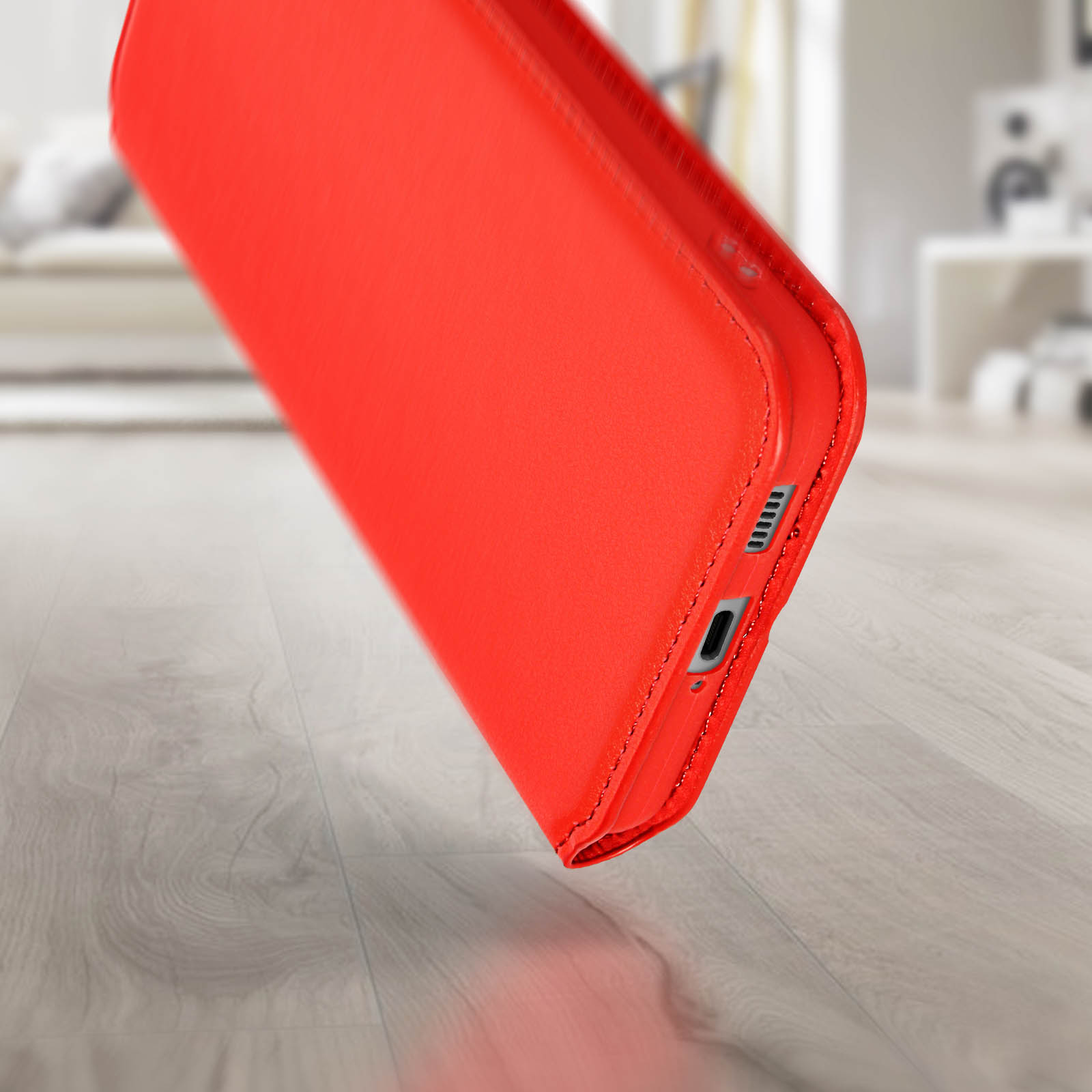 Rode telefoonhoes, close-up, op houten vloer. Zijkant met poort zichtbaar. Eenvoudig en schoon.