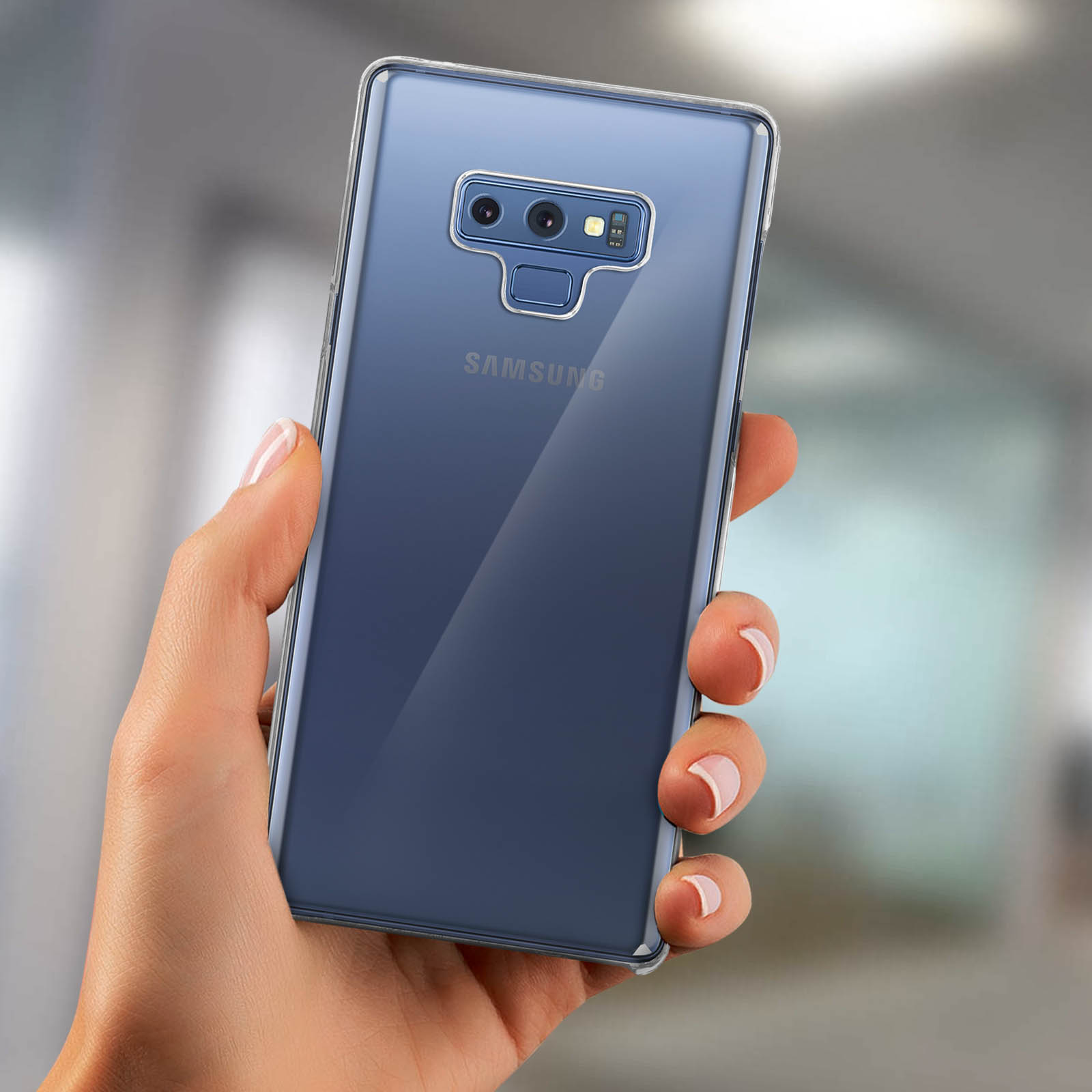 Una custodia trasparente per telefono tenuta in mano, che mostra il retro di un telefono blu.