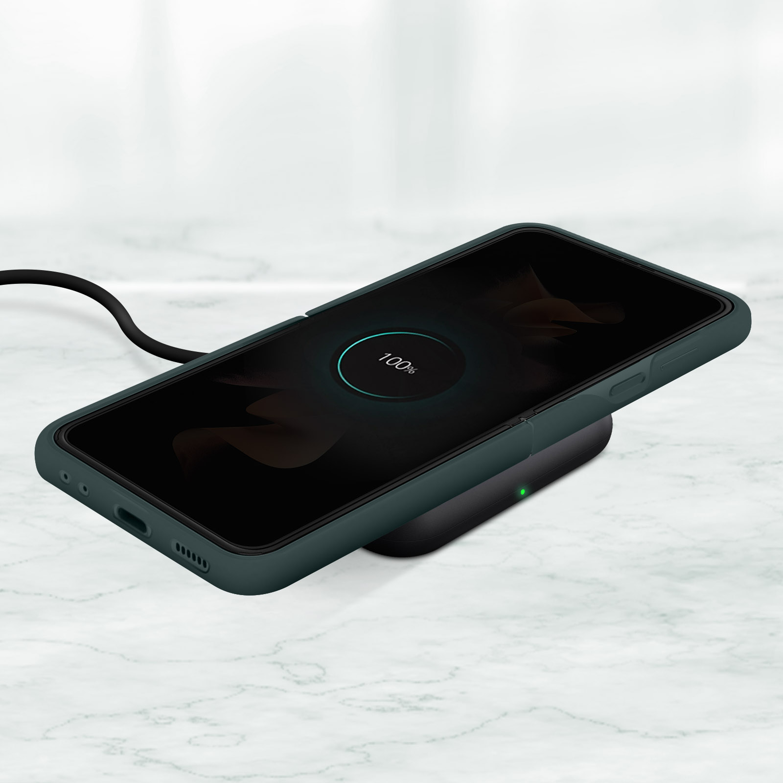 Telefono in una custodia verde su un caricabatterie wireless. Lo schermo mostra il 100% di carica su marmo.