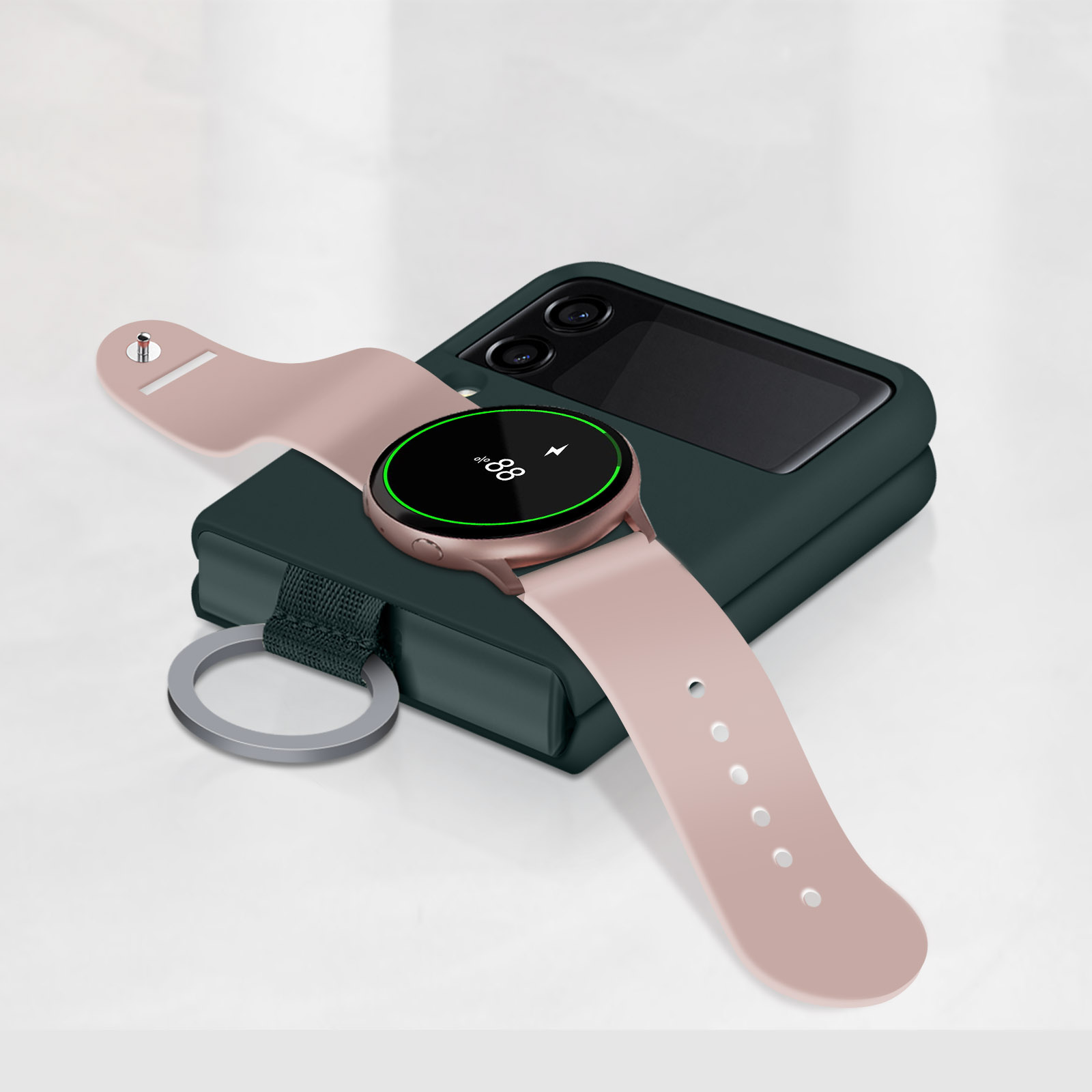 Smartwatch su base di ricarica e telefono piegato su tavolo bianco.