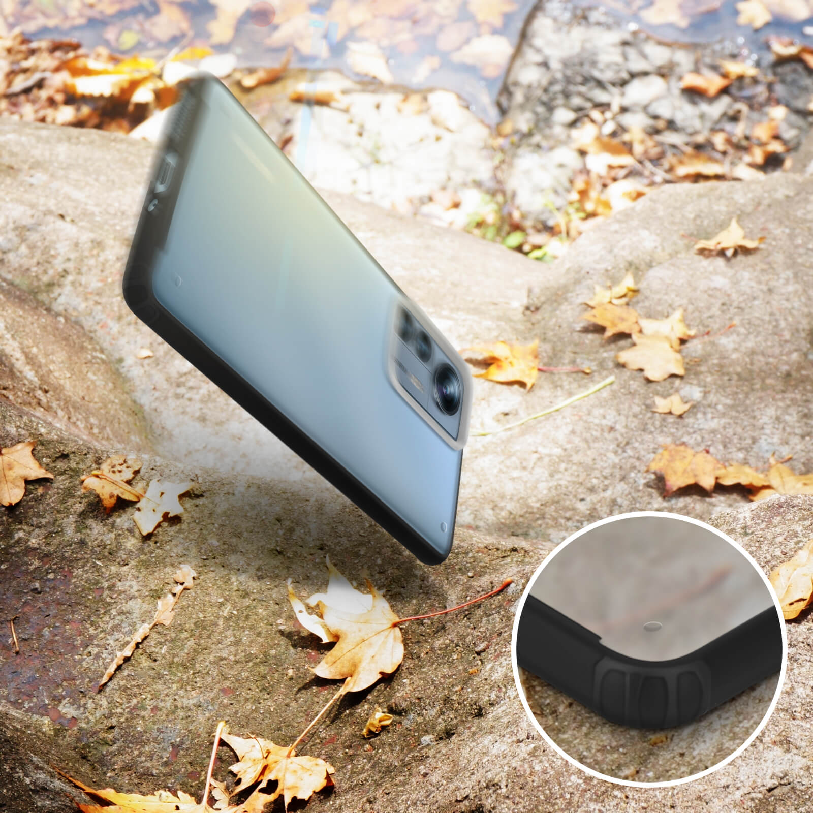 Telefono in una custodia nera che cade su una superficie di pietra, con acqua e foglie.