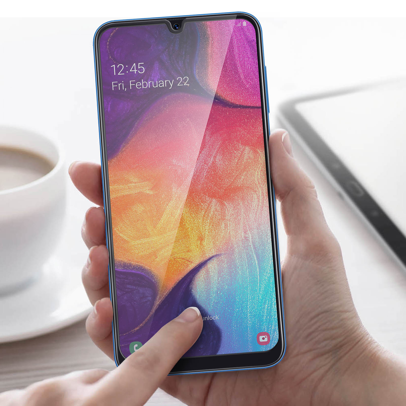 Persona che tiene il telefono, usa una protezione per lo schermo. Lo schermo mostra l'ora e la data.