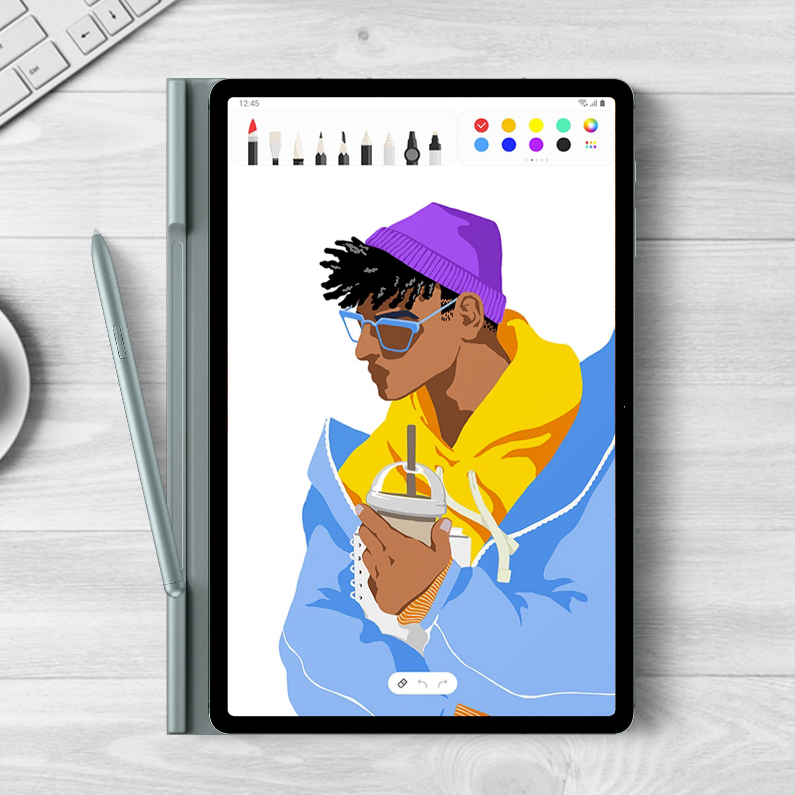 La tablette montre un dessin d'une personne avec un chapeau violet et une veste bleue. Un stylo et un clavier sont visibles.