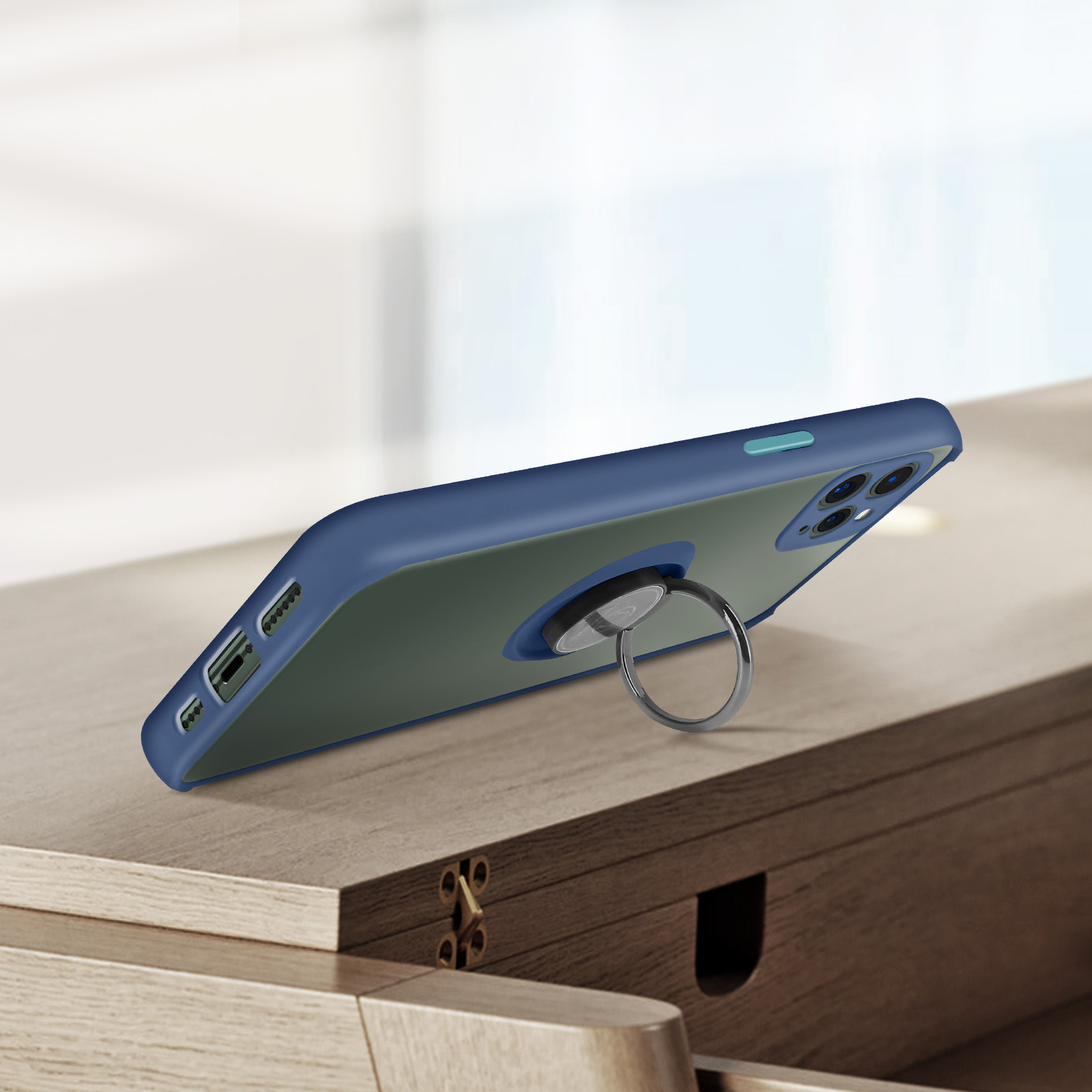 Coque de téléphone bleue avec anneau sur une table en bois. La coque est sur le côté, montrant les boutons.