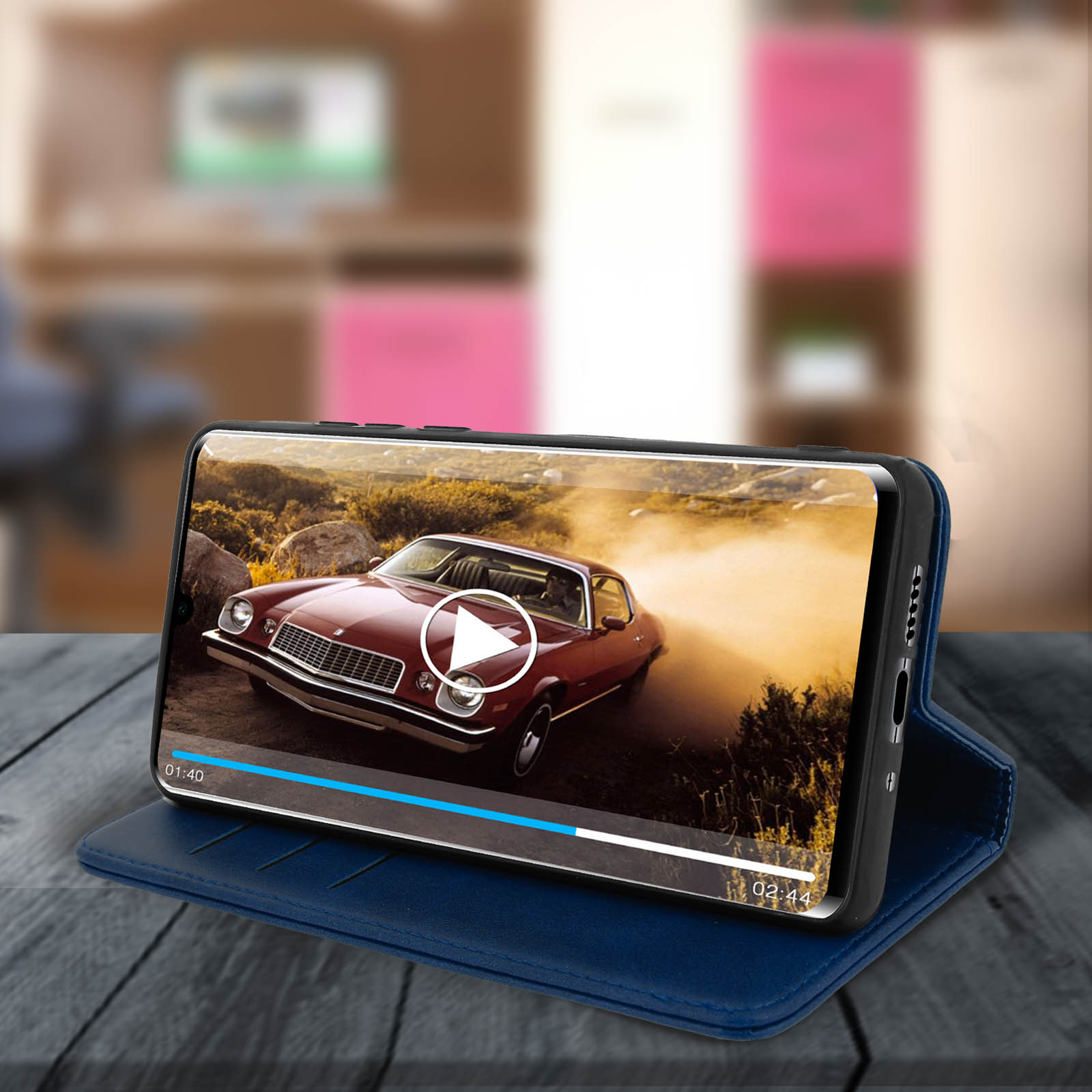 Un telefono in una custodia che mostra un video di un'auto. Il telefono è appoggiato su una custodia blu.