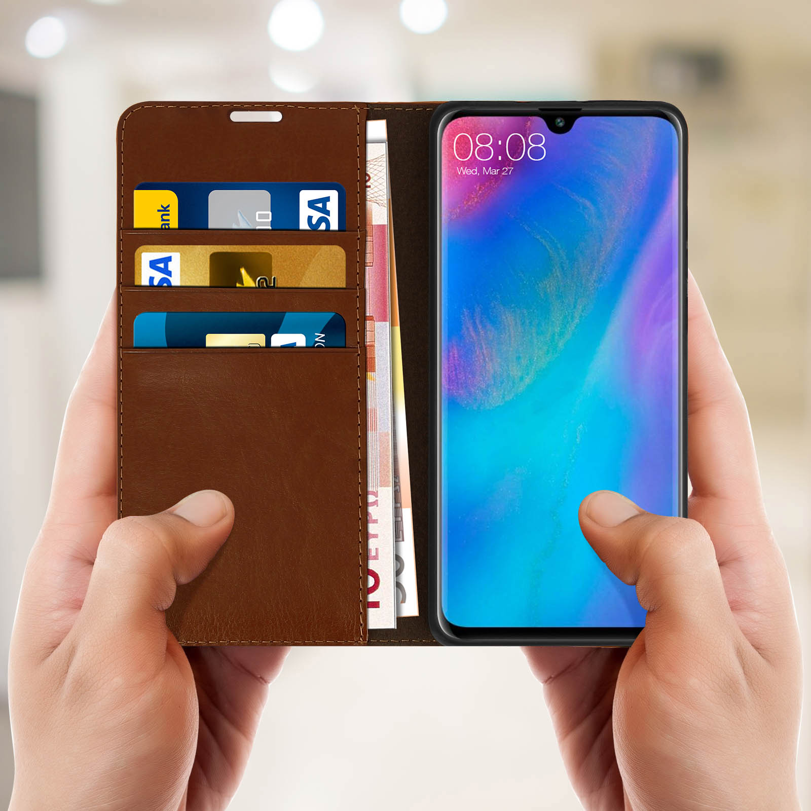 Mani che tengono una custodia marrone con telefono e carte.