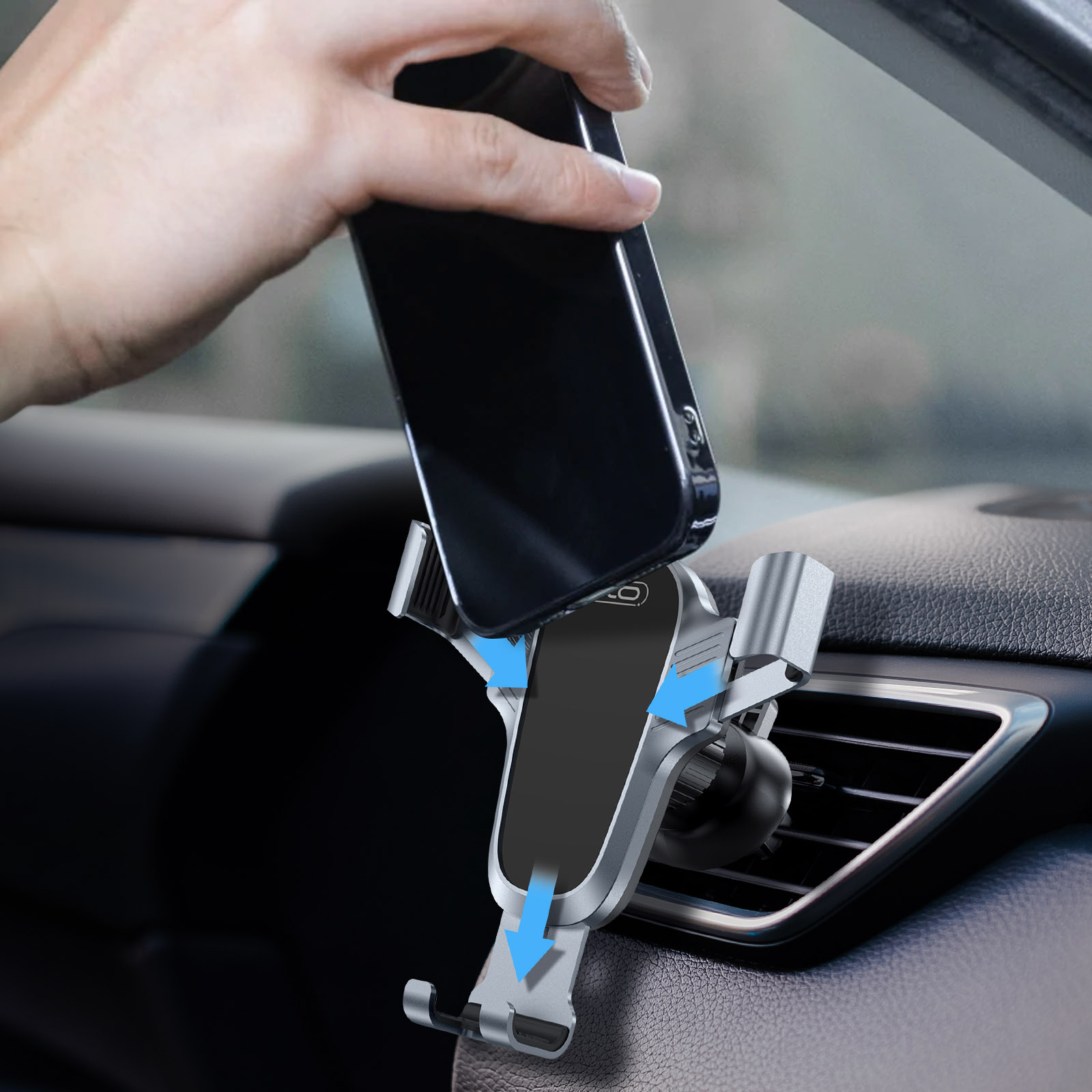 Mano colocando un teléfono en un soporte para coche. El soporte es plateado y negro.