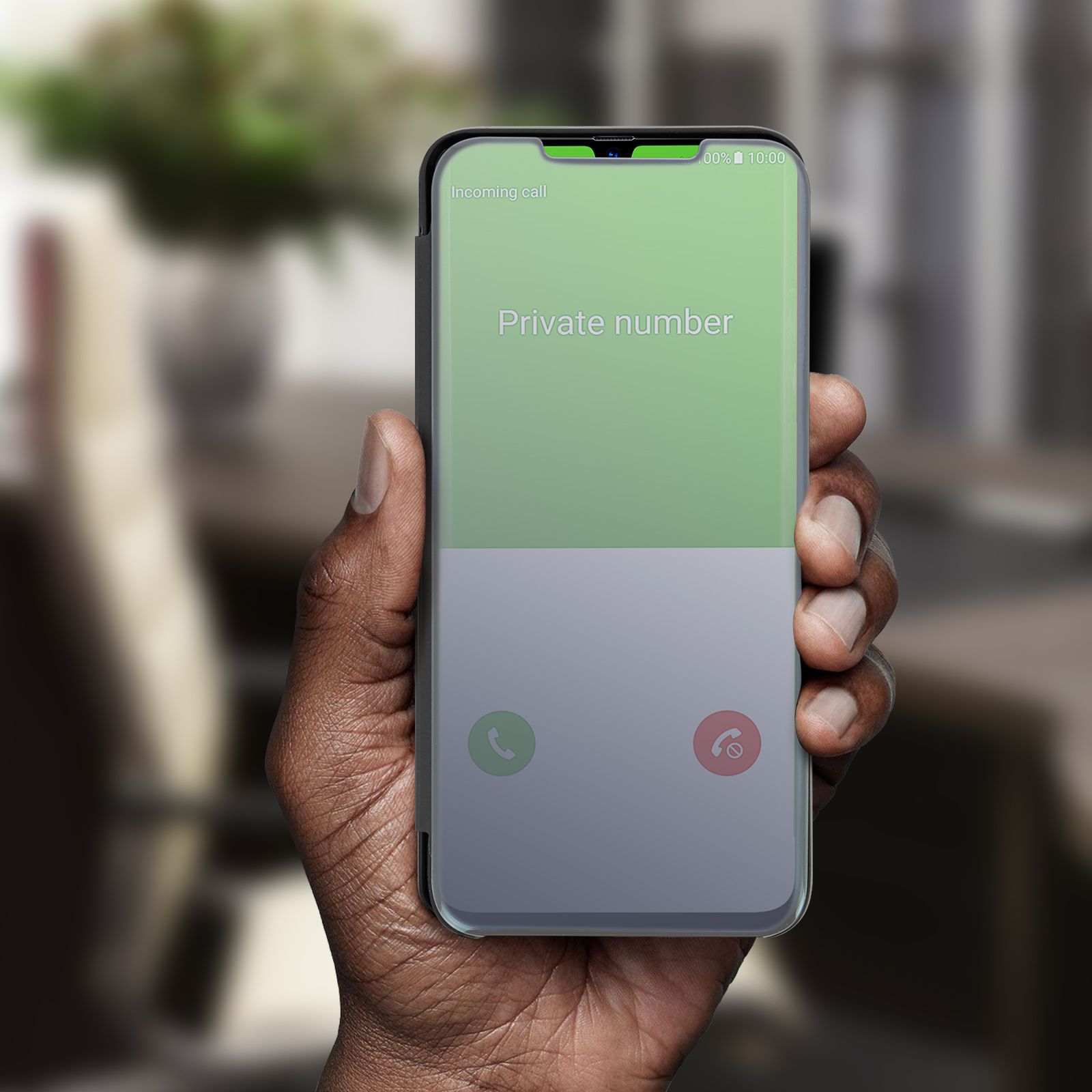 Mano che tiene un telefono con una schermata di chiamata in arrivo. Lo schermo dice Numero privato.