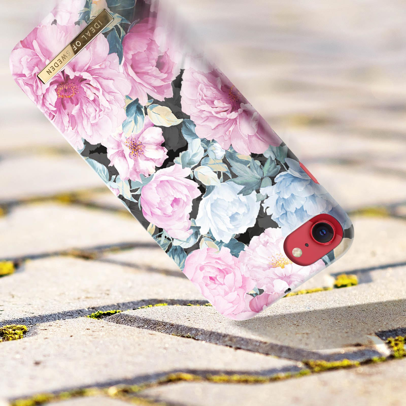 Blumen-Handyhülle mit rosa und weißem Blumendesign. Die Hülle ist abgewinkelt mit verschwommenem Hintergrund.