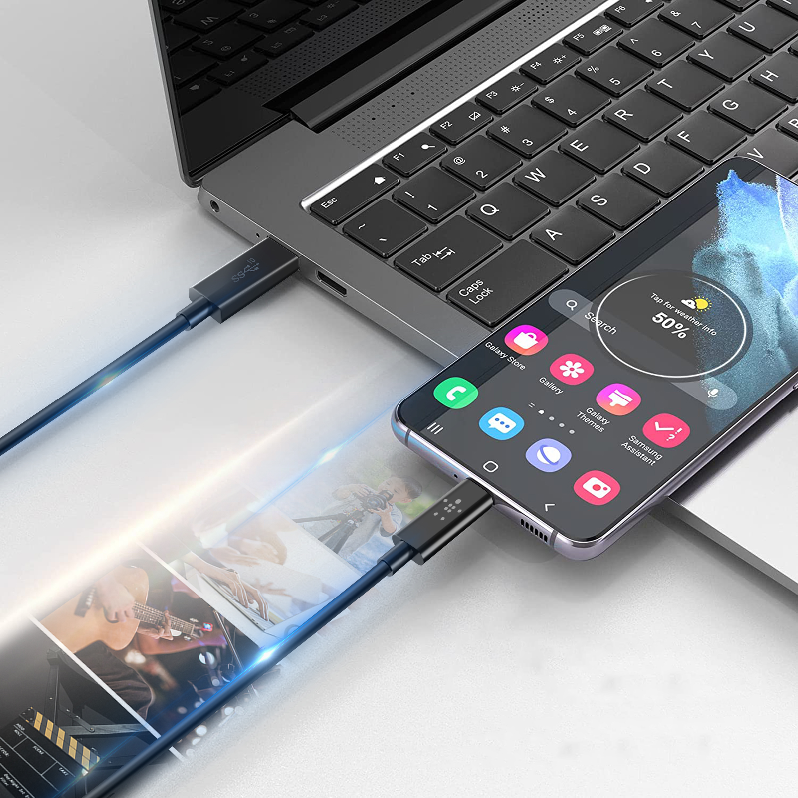 A laptop with a phone plugged in. The phone shows the weather and a search bar.