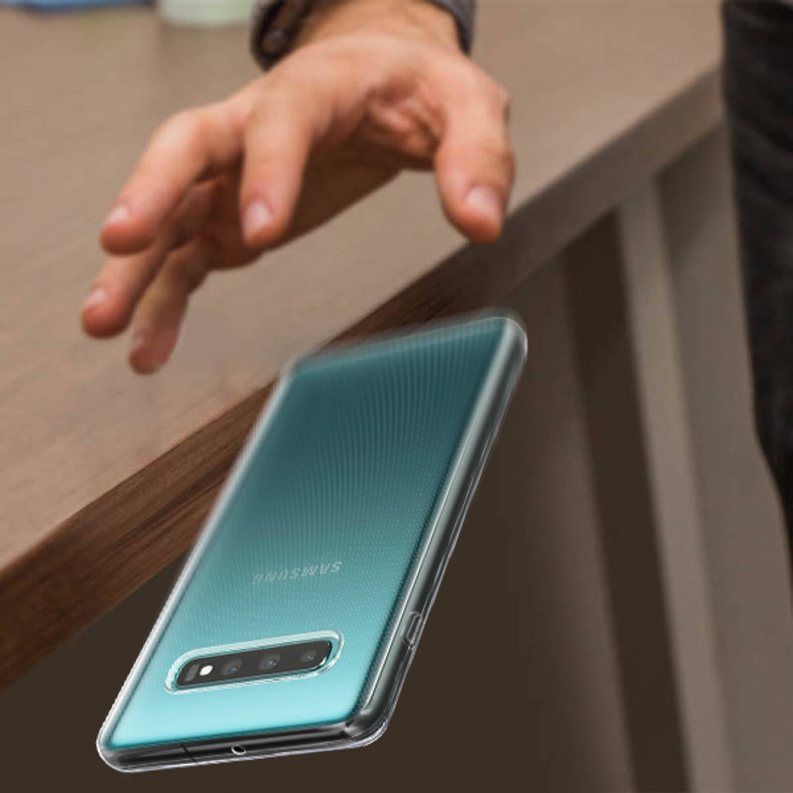 Una mano si avvicina a un telefono con una custodia trasparente. Il telefono è su un tavolo.