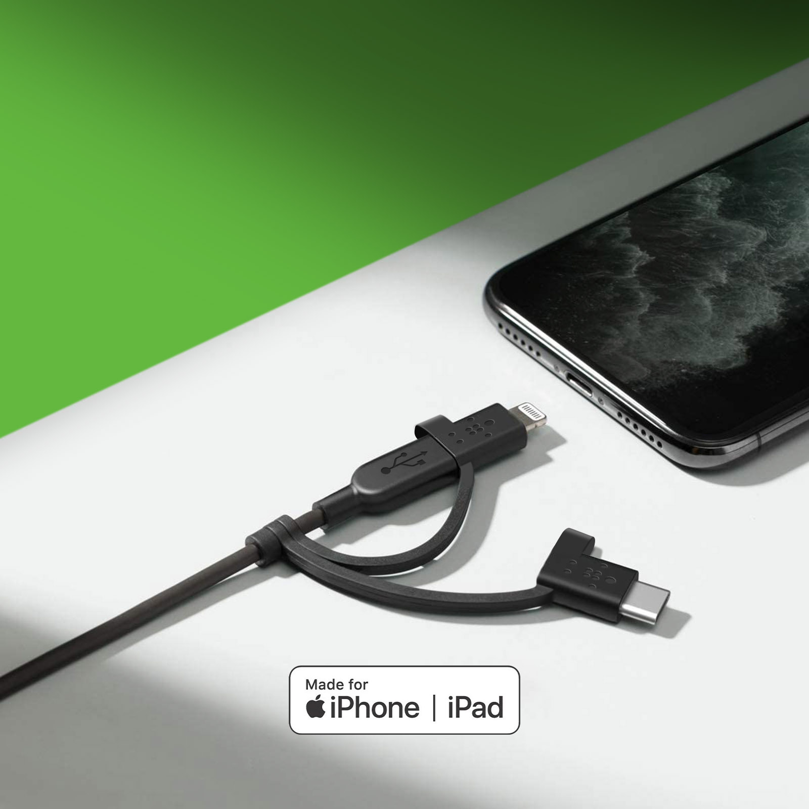 Telefon ve yeşil arka plan ile siyah USB-C ve Lightning kablosu.