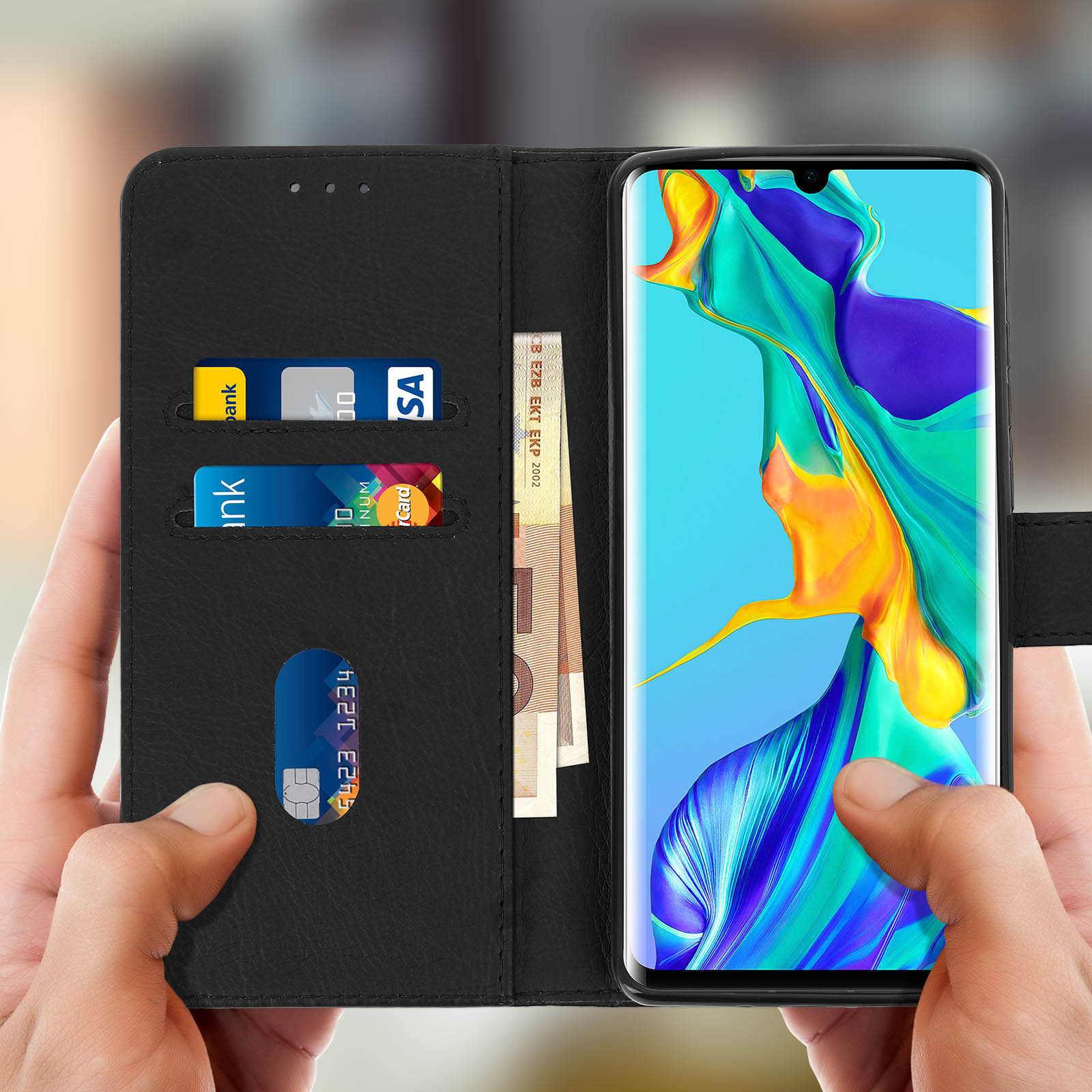 Una persona che tiene un telefono con carte di credito e denaro in una custodia a portafoglio. Custodia nera.