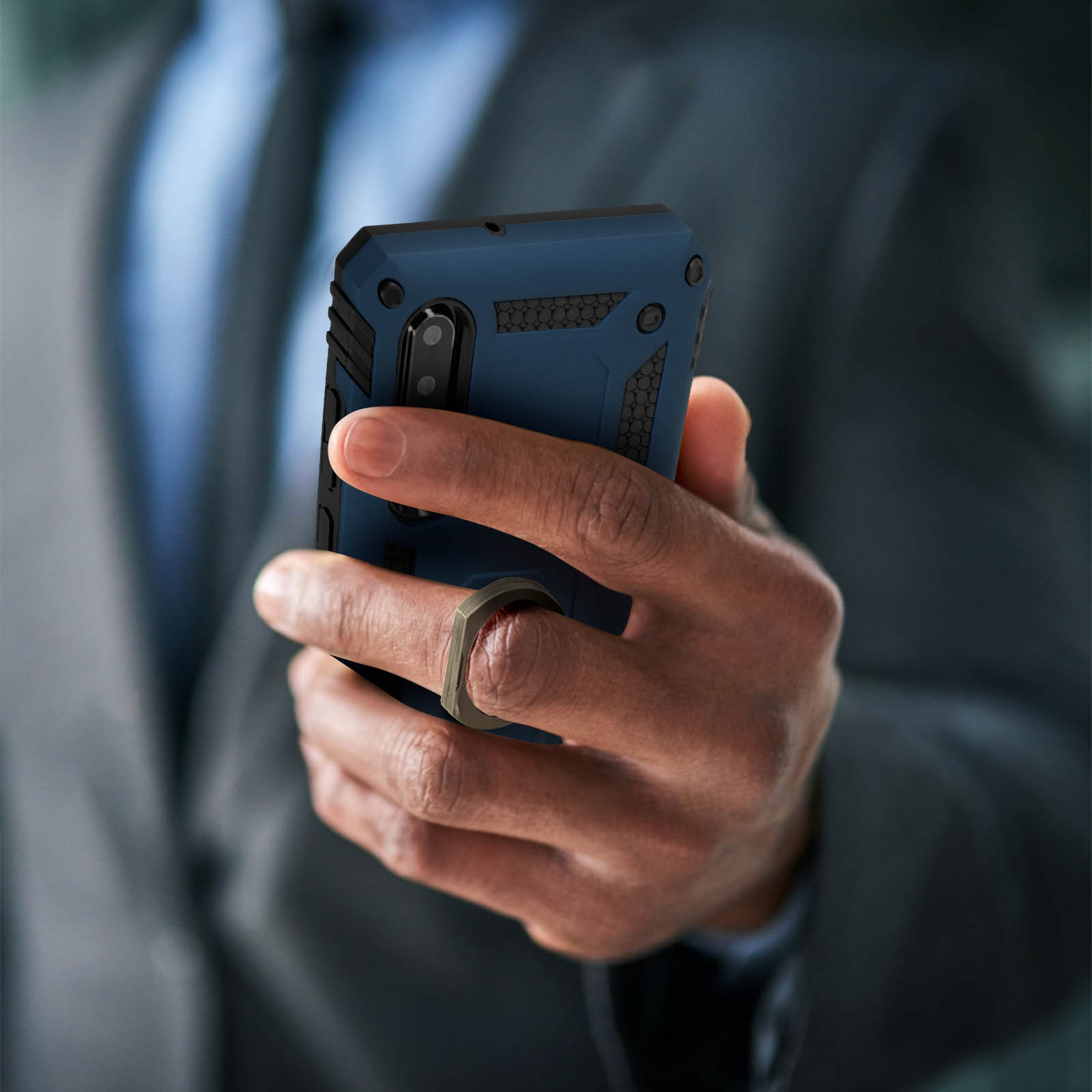 Hand die een blauwe en zwarte telefoonhoes vasthoudt met een ringhouder.