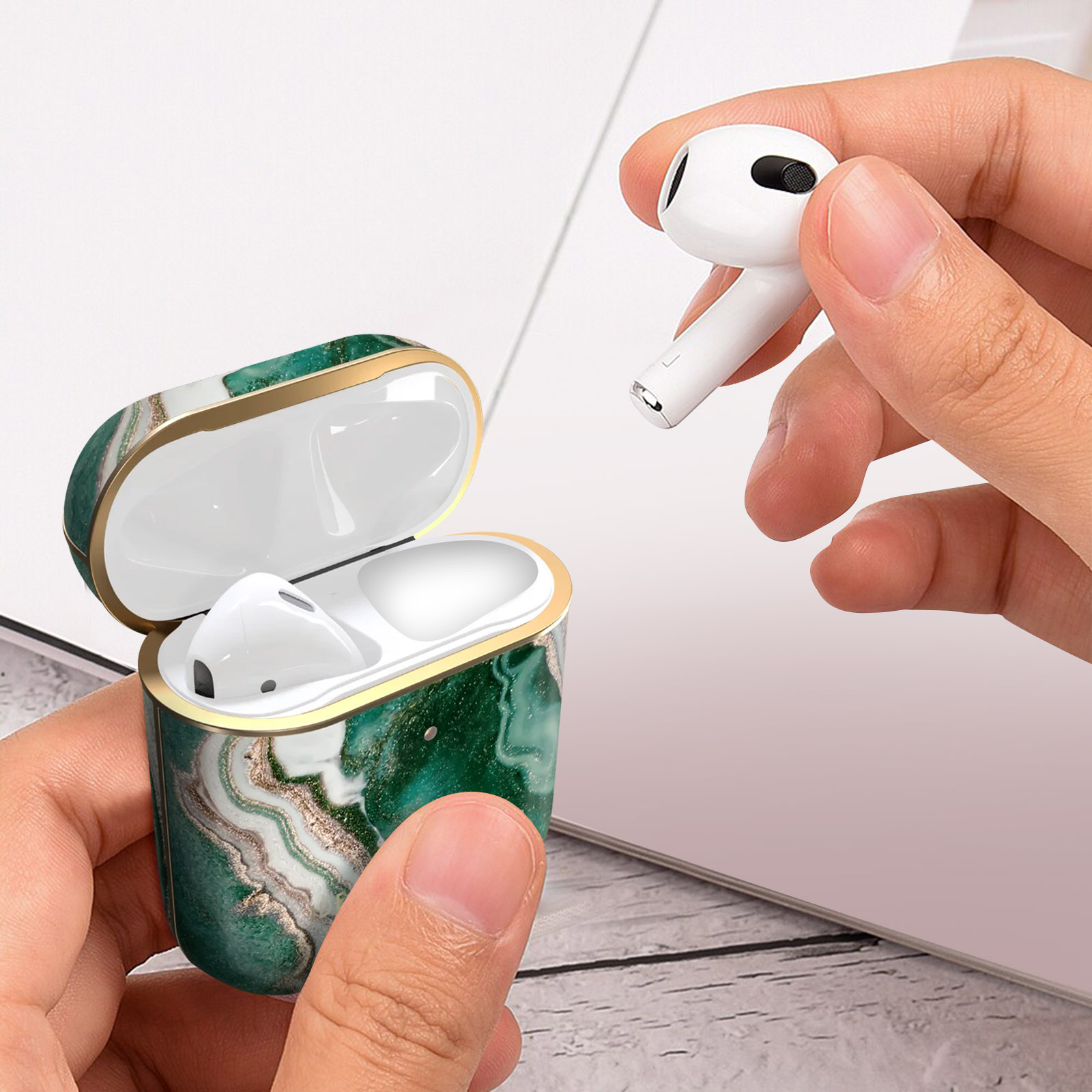 Funda blanca de AirPods con el auricular que se está quitando. La funda es verde y dorada.