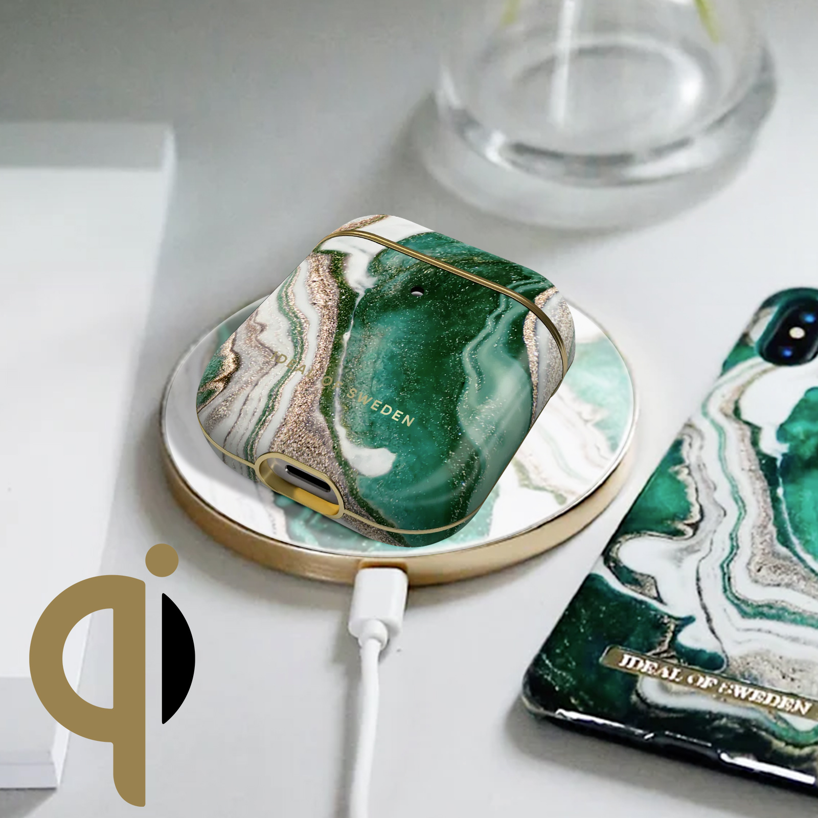 Cargador inalámbrico de diseño de mármol verde con borde dorado. Una funda de teléfono está encima.