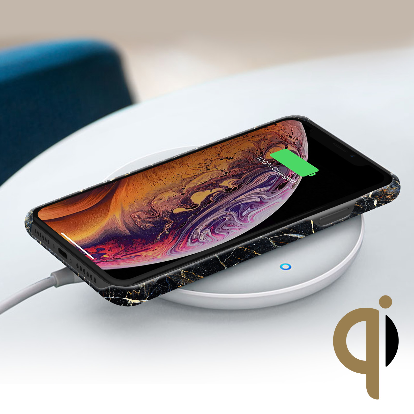 Mermer desenli bir kılıfı olan bir telefon, kablosuz bir şarj cihazının üzerinde duruyor ve %100 şarj gösteriyor. Bir Qi logosu görünür.