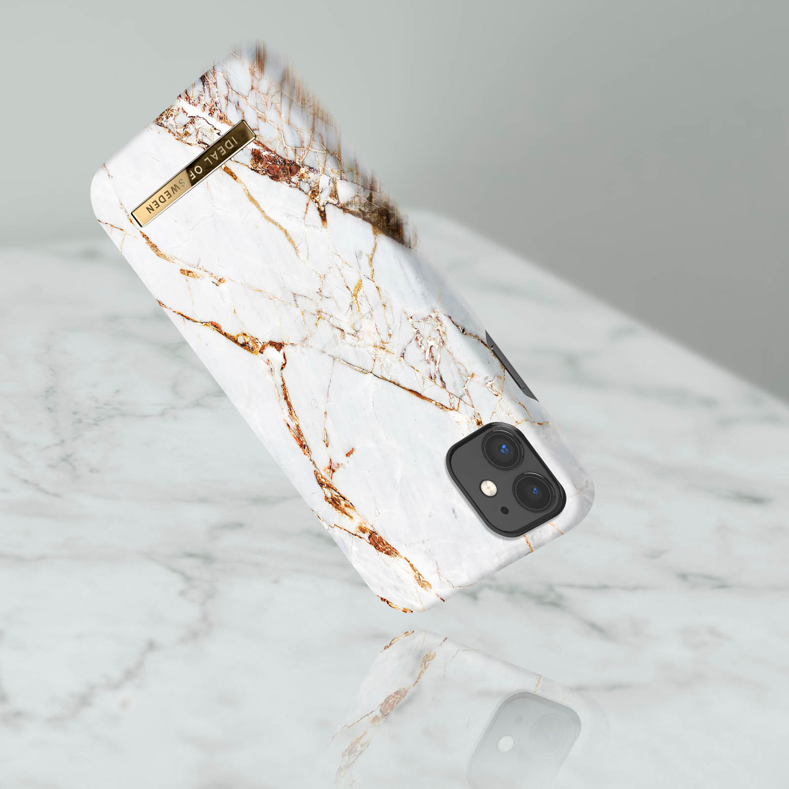 Weiße Handyhülle mit Telefon darin. Die Hülle hat ein Marmormuster. Das Telefon steht auf weißem Untergrund.