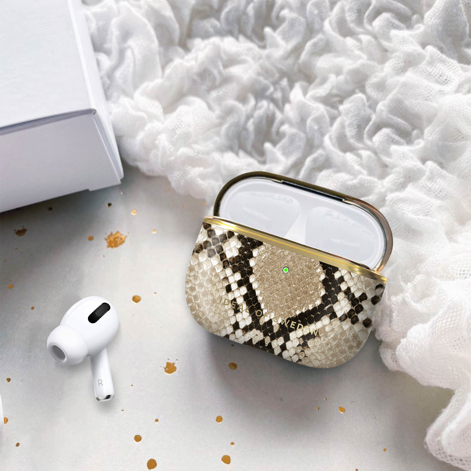 Funda de auriculares con patrón de piel de serpiente abierta, auriculares blancos.