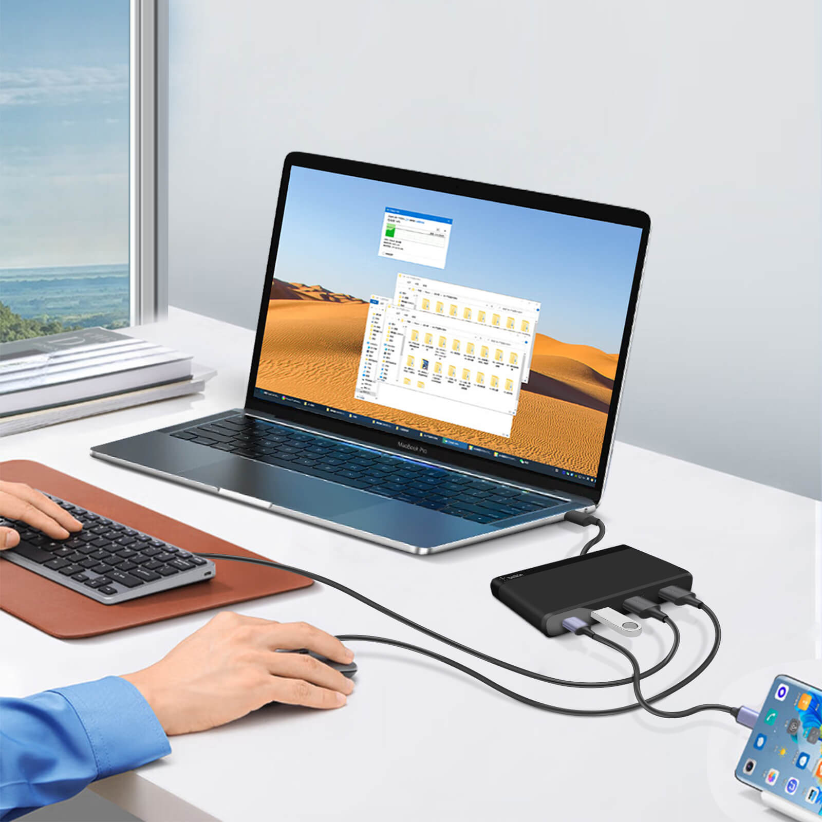 Ein Laptop mit Monitor, Maus und Tastatur, mit einem Telefon, das an einen Hub angeschlossen ist.