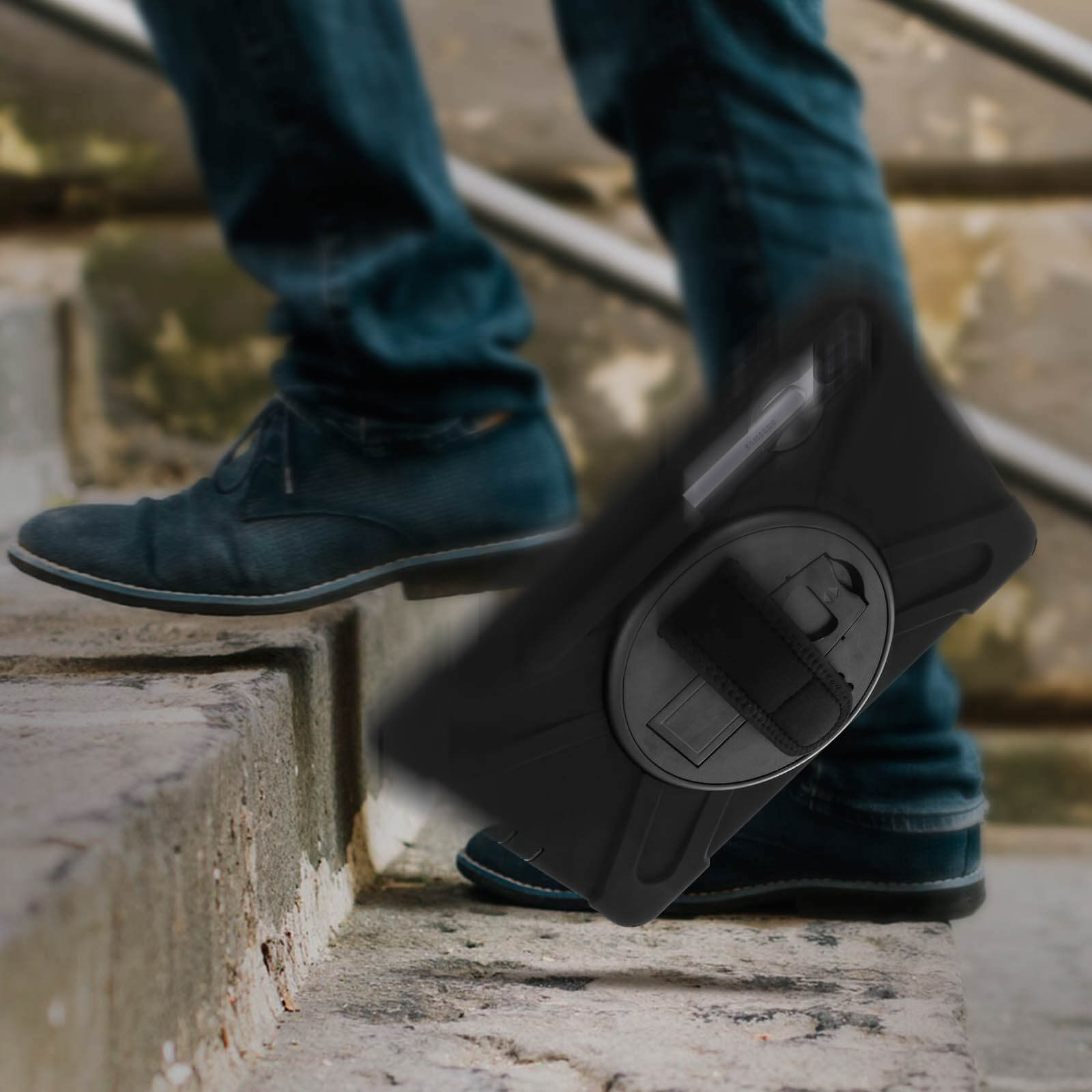 Person geht Treppen runter, hält ein schwarzes Tablet in einer Hülle mit Handschlaufe.