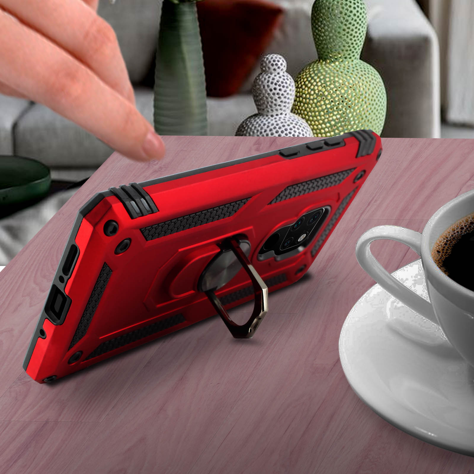 Un étui de téléphone rouge avec un porte-anneau est sur une surface en bois. Une tasse de café est à côté du téléphone.