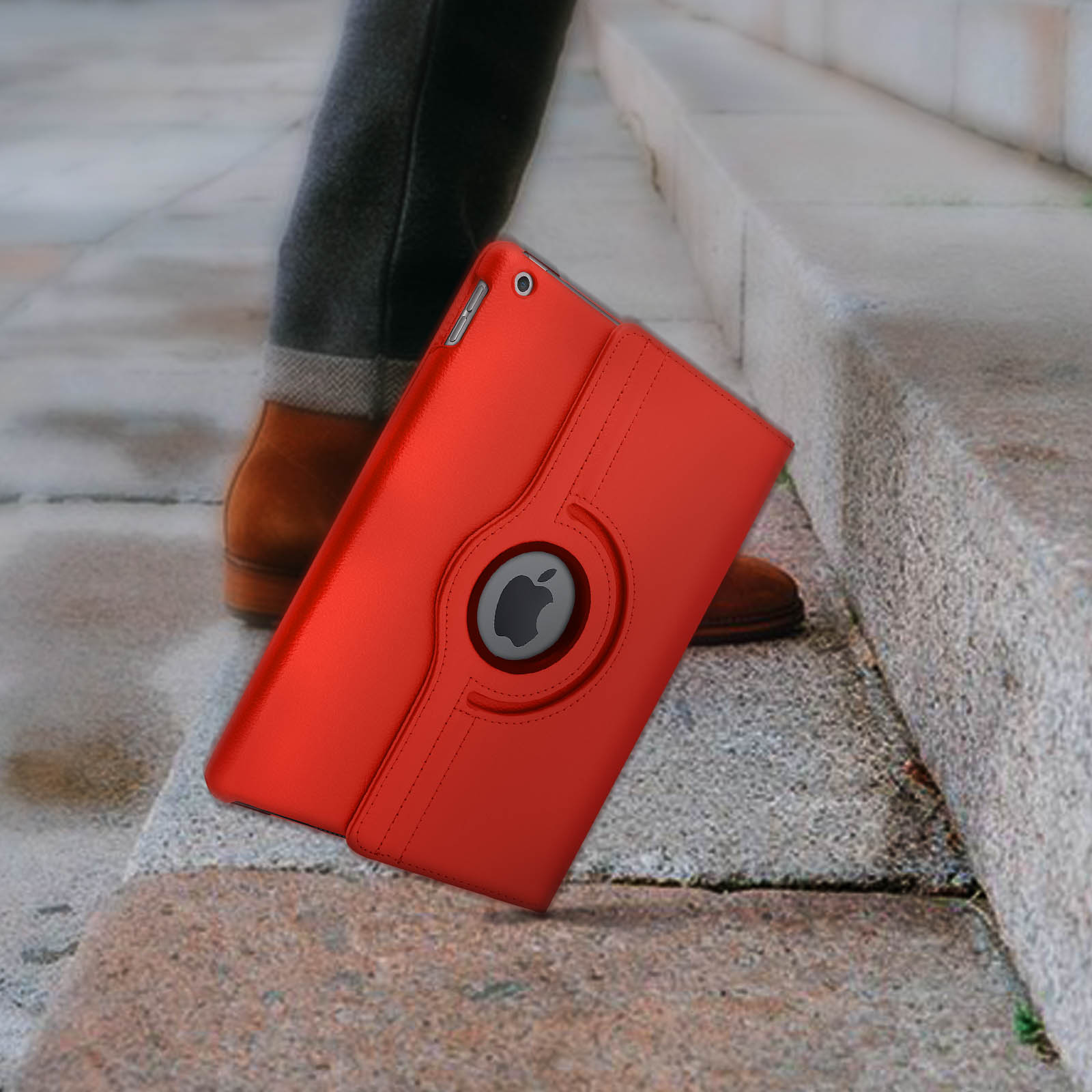 Custodia rossa per tablet sulle scale. Un piede con scarpa marrone sullo sfondo.