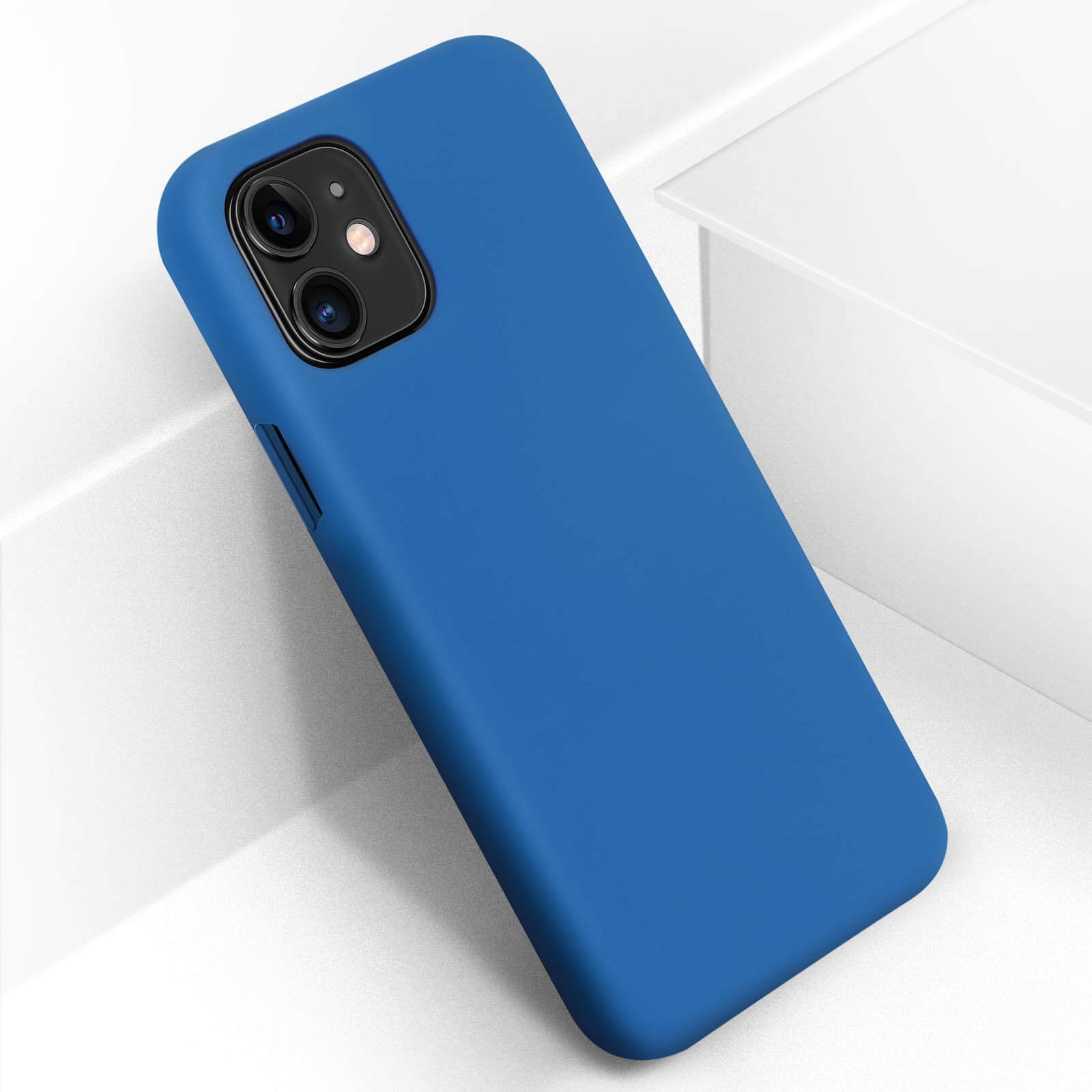 Coque de téléphone bleue avec découpes pour caméra sur une surface blanche. L'étui est uni et propre.