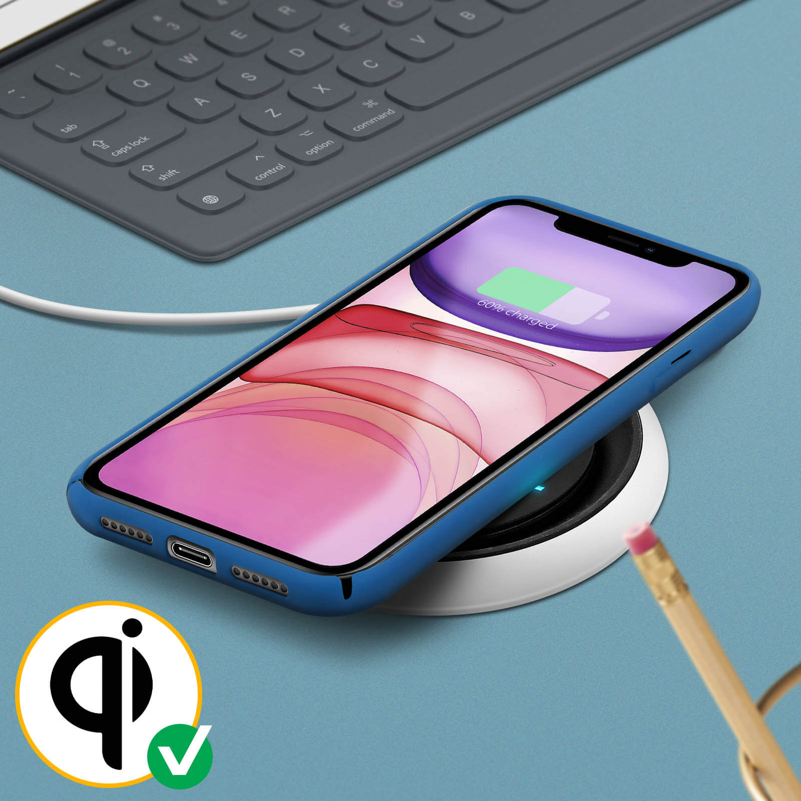 Téléphone bleu dans un étui se rechargeant sans fil. Le téléphone a un indicateur de batterie vert. Crayon dans le coin.