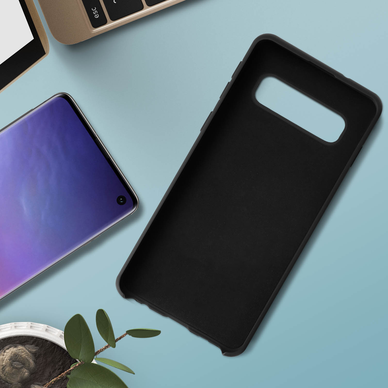 Una custodia nera per telefono accanto a uno schermo viola di un telefono o tablet, con un laptop.