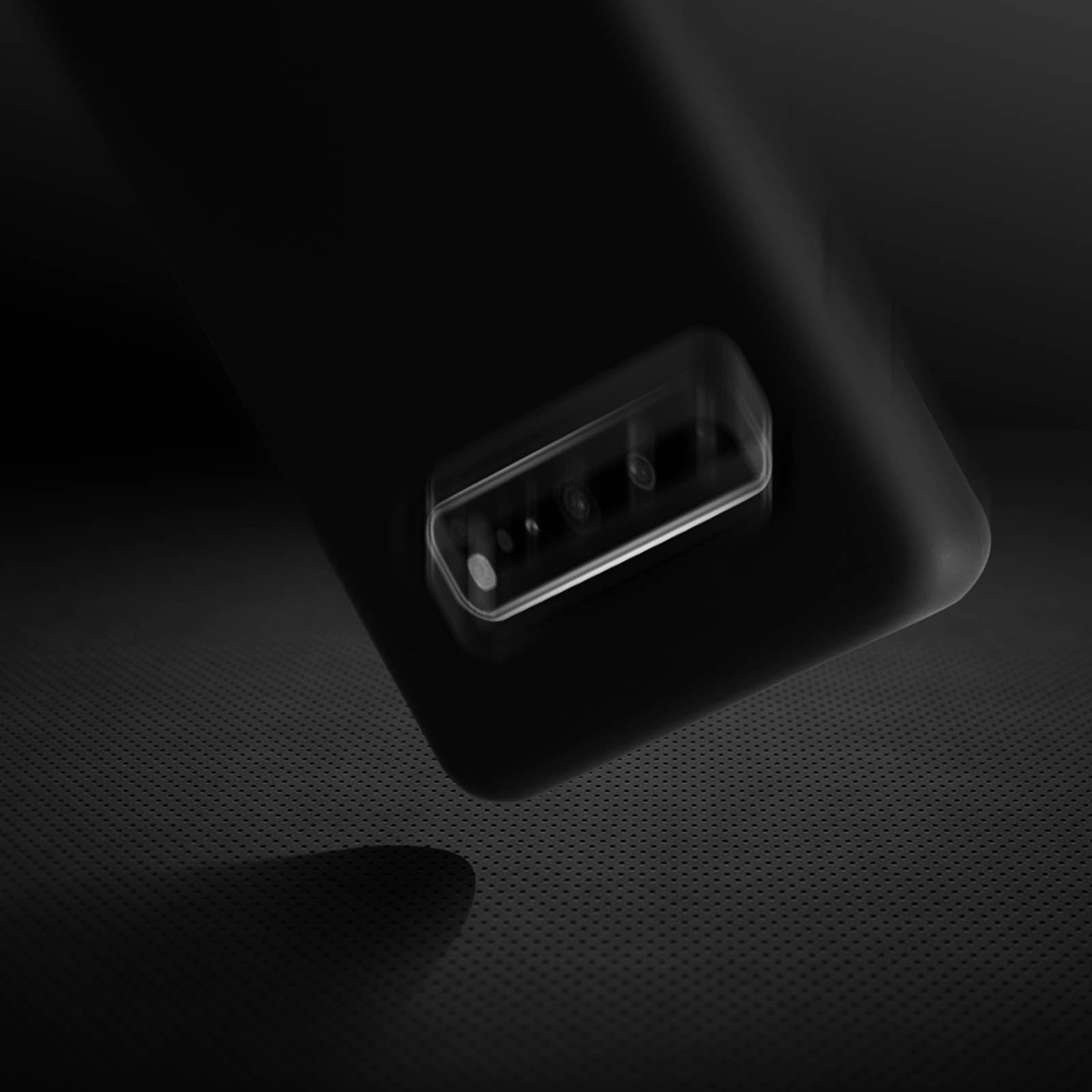 Dos de téléphone noir et texturé avec trois lentilles, fond flou.
