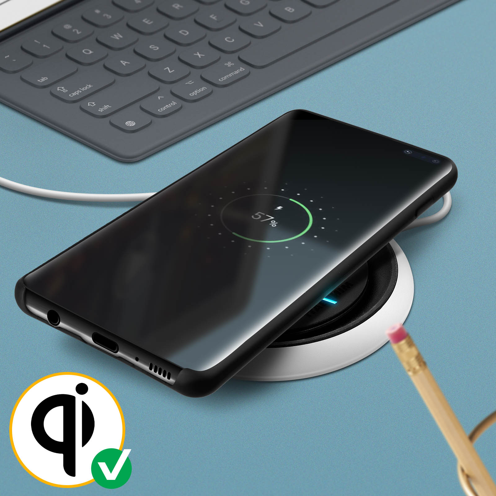 Téléphone se chargeant sans fil sur un socle de chargement blanc avec crayon et clavier.