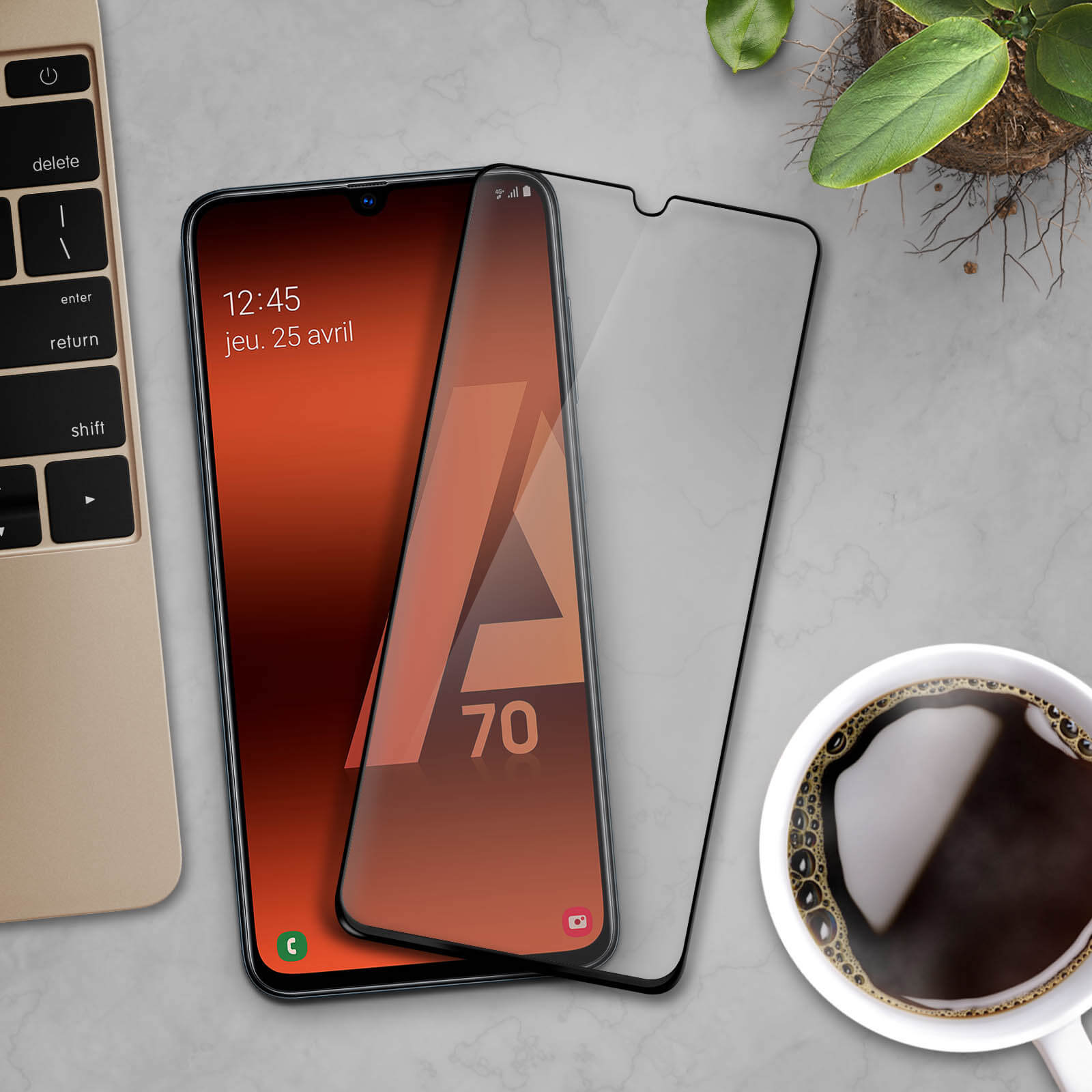 Smartphone avec un protecteur d'écran. L'écran affiche la date et la lettre A. Le fond est clair.