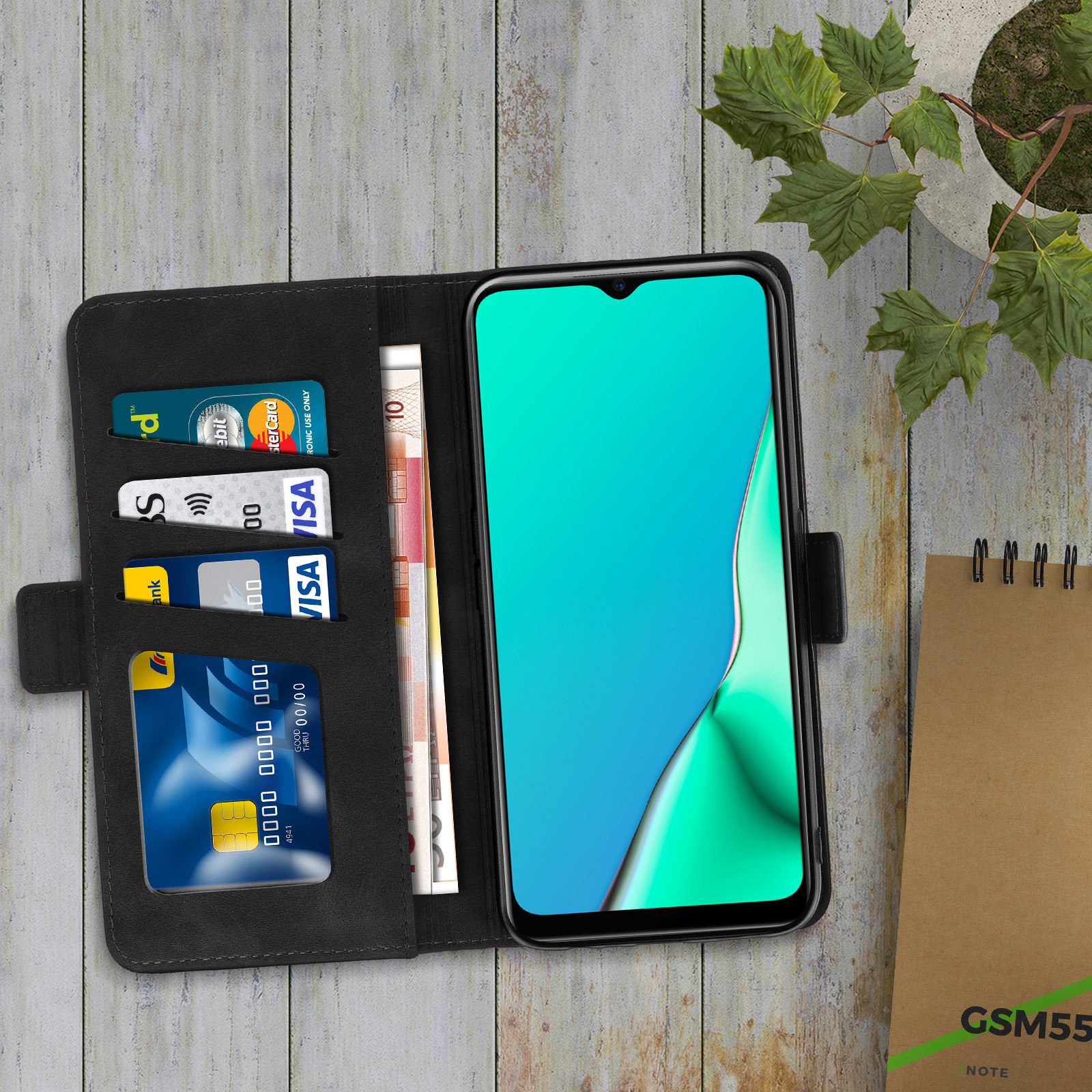 Smartphone in una custodia a libro nera, aperto per mostrare carte di credito e denaro.