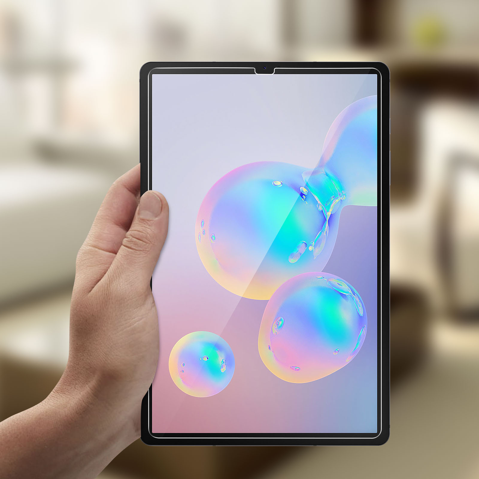 Tablet tenuto in mano, schermo che mostra bolle colorate. Sfondo sfocato.