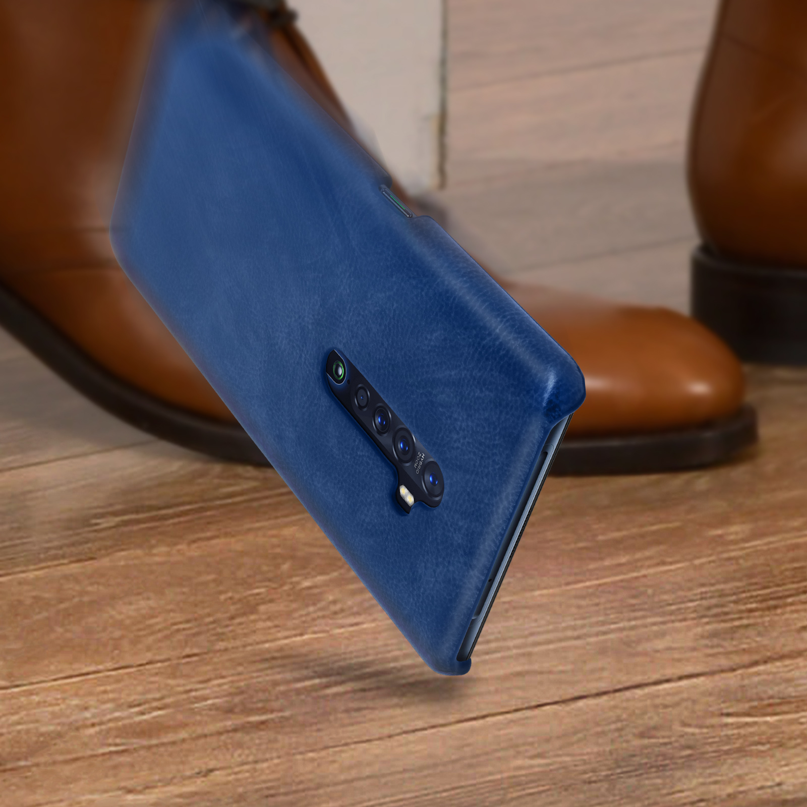 Custodia blu per telefono con telefono all'interno. Il telefono è angolato davanti a scarpe di pelle marrone.