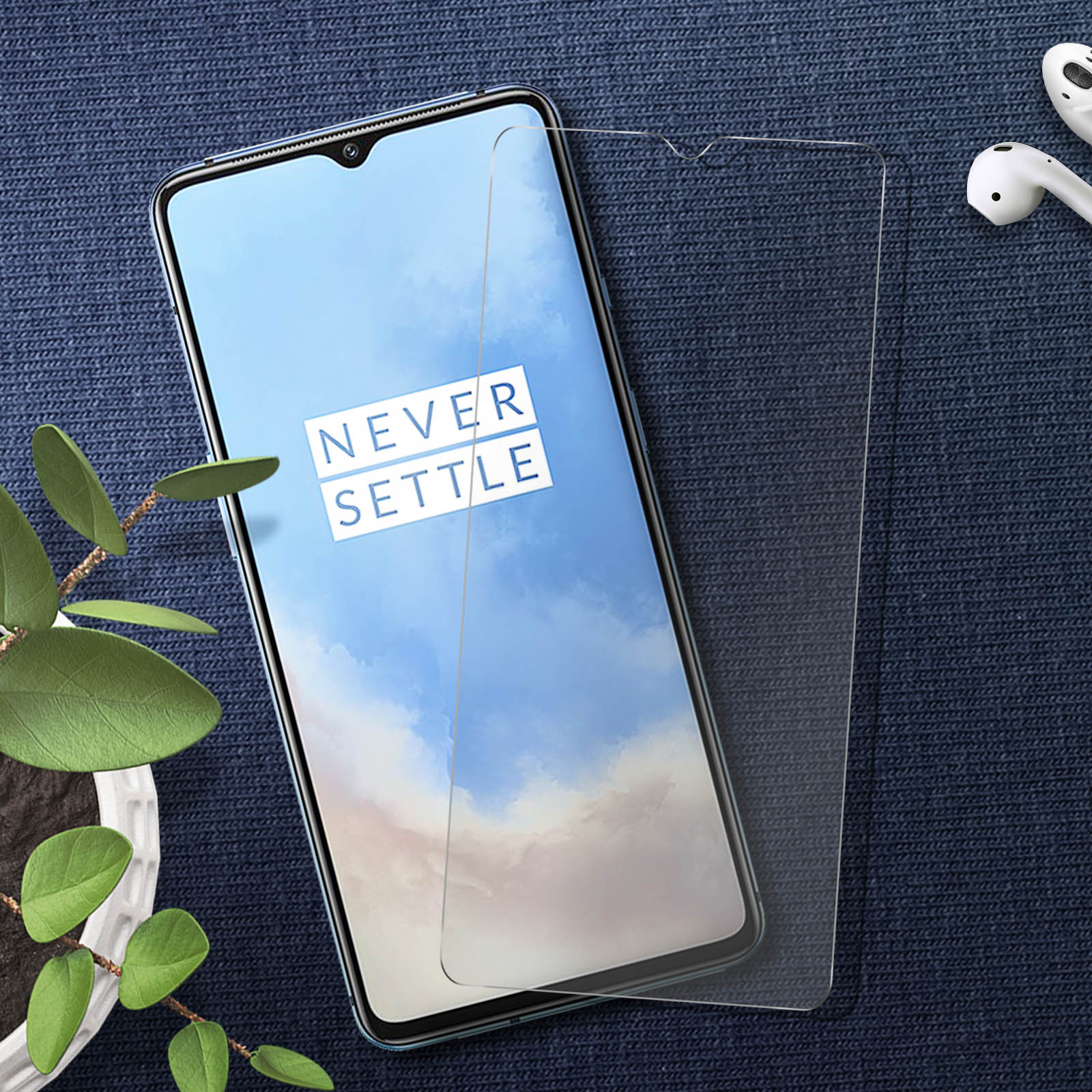 Smartphone con protezione schermo applicata e sfondo blu con oggetti bianchi.