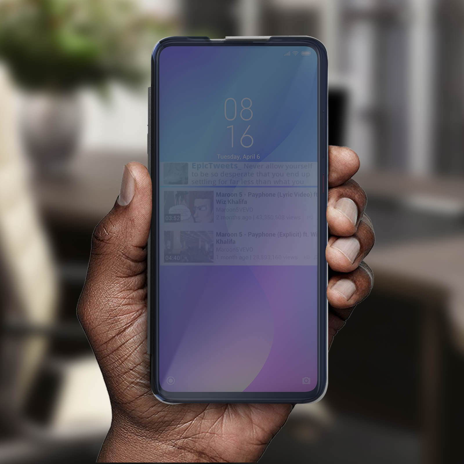 Una mano che tiene un telefono con schermo blu. Il telefono mostra un feed video.