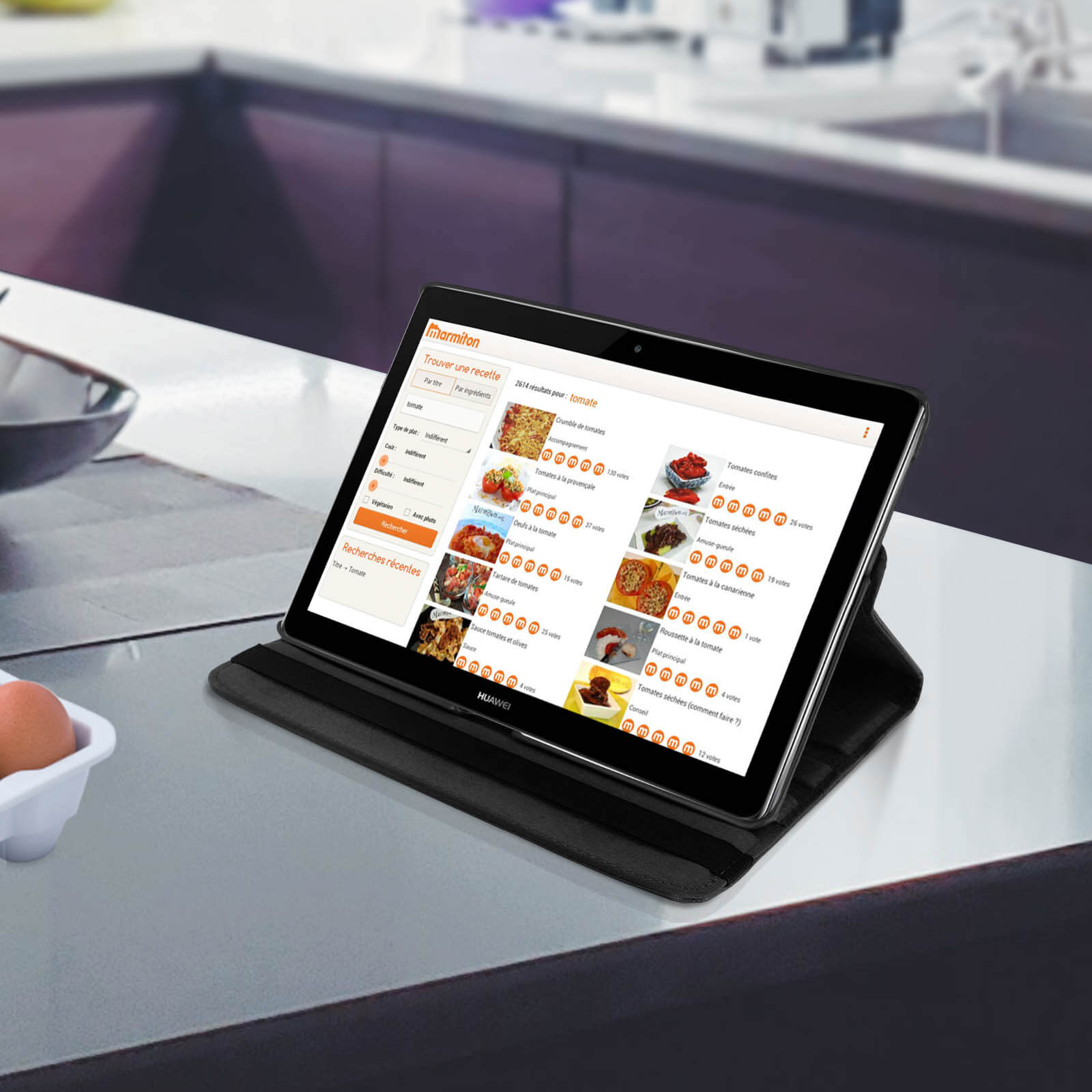 Tablet su un tavolo da cucina, che mostra le ricette. Custodia nera, schermo che mostra le ricette.