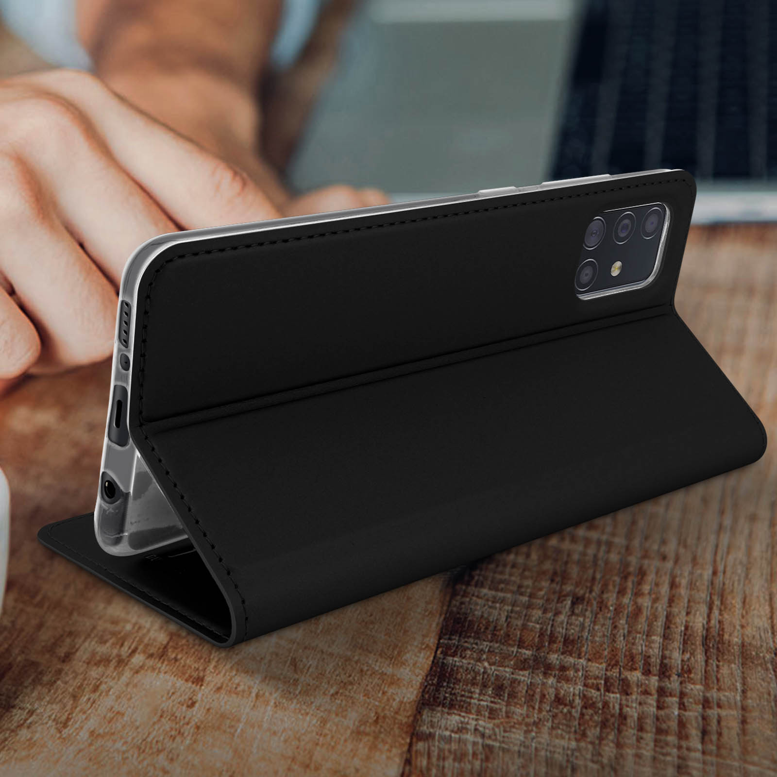 Zwarte telefoonhoes met de telefoon rechtop. Houten achtergrond.