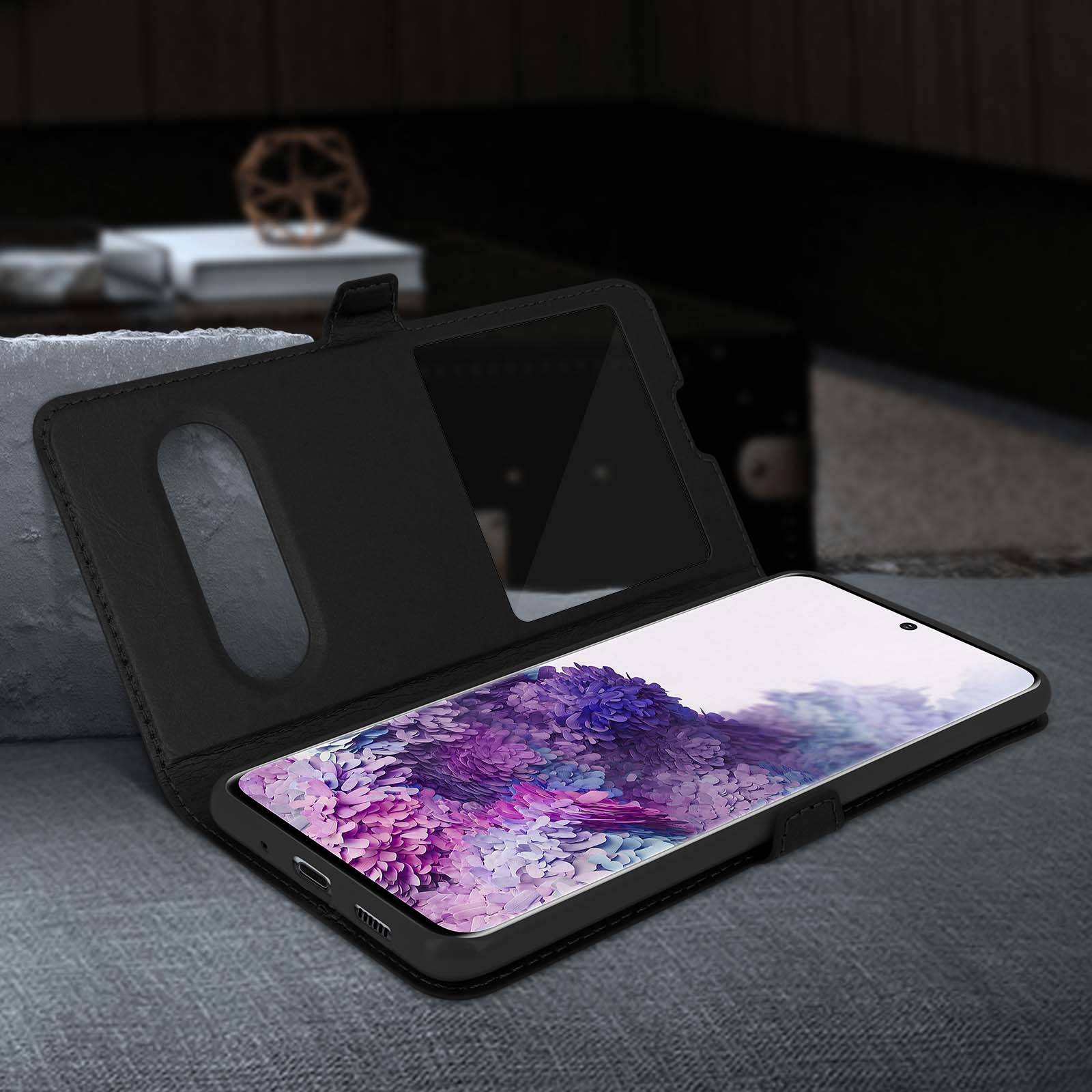 Custodia nera aperta, che mostra lo schermo del telefono. Il telefono è su una superficie grigia.