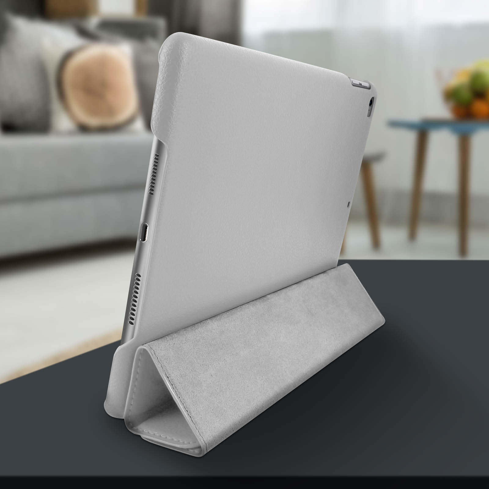 Un tablet grigio in una custodia. La custodia viene utilizzata come supporto. Lo sfondo è sfocato.