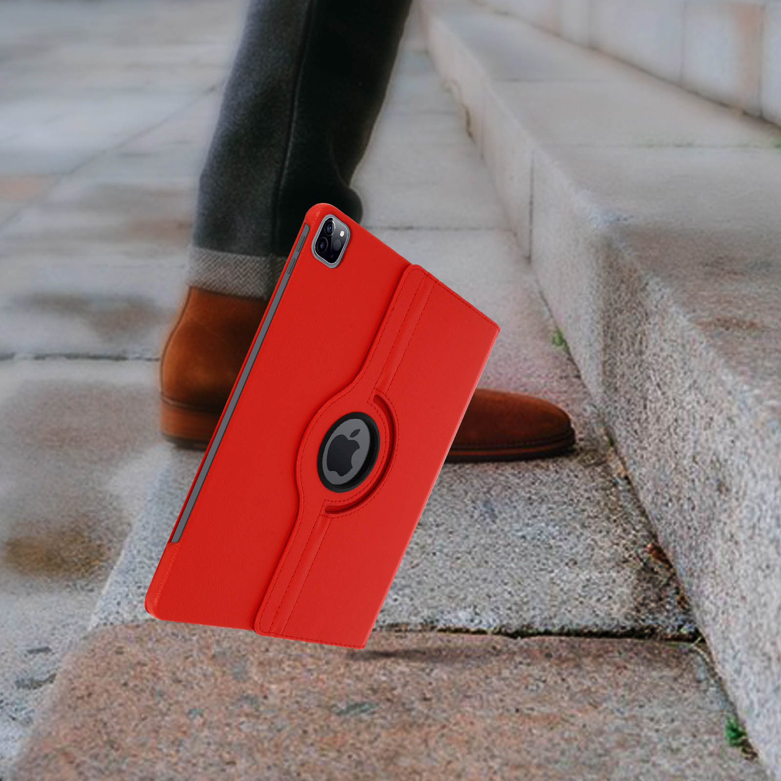 Una custodia rossa per tablet che cade sulle scale, una scarpa marrone è visibile sullo sfondo.