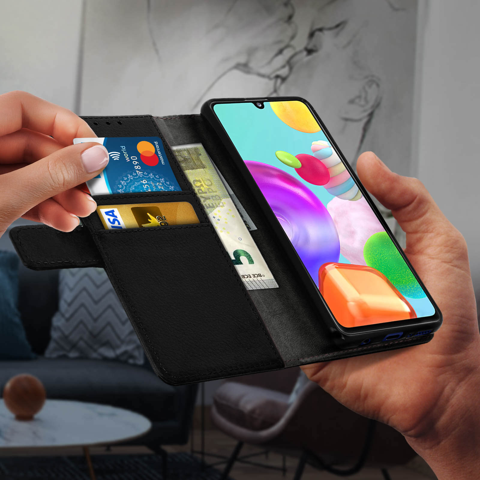 Main tenant un téléphone avec des cartes et de l'argent dans l'étui.