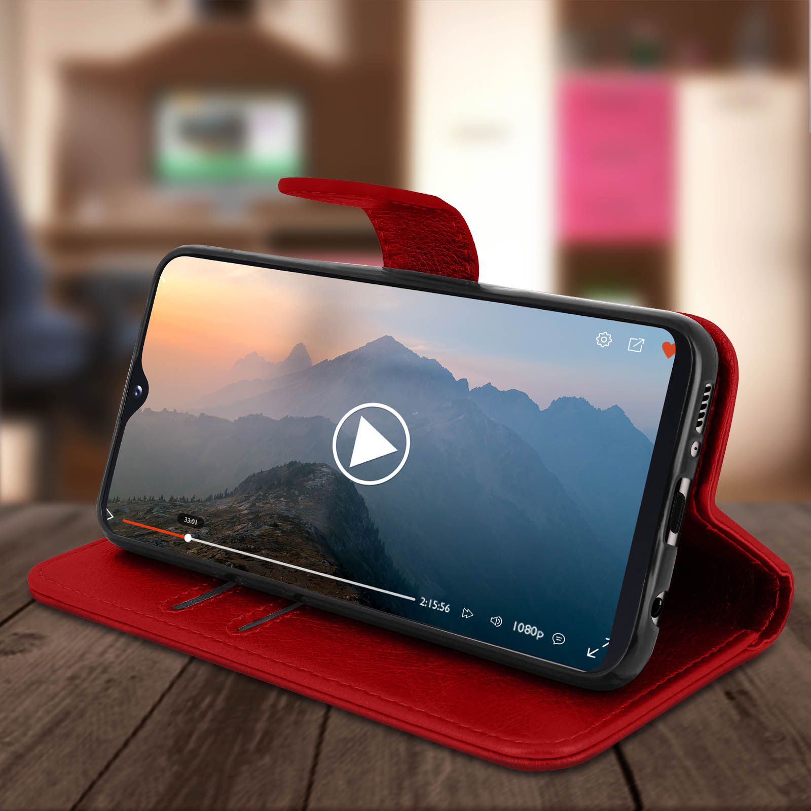 Telefoon in een rode leren hoes, met een video op het scherm. De scène is een kamer.