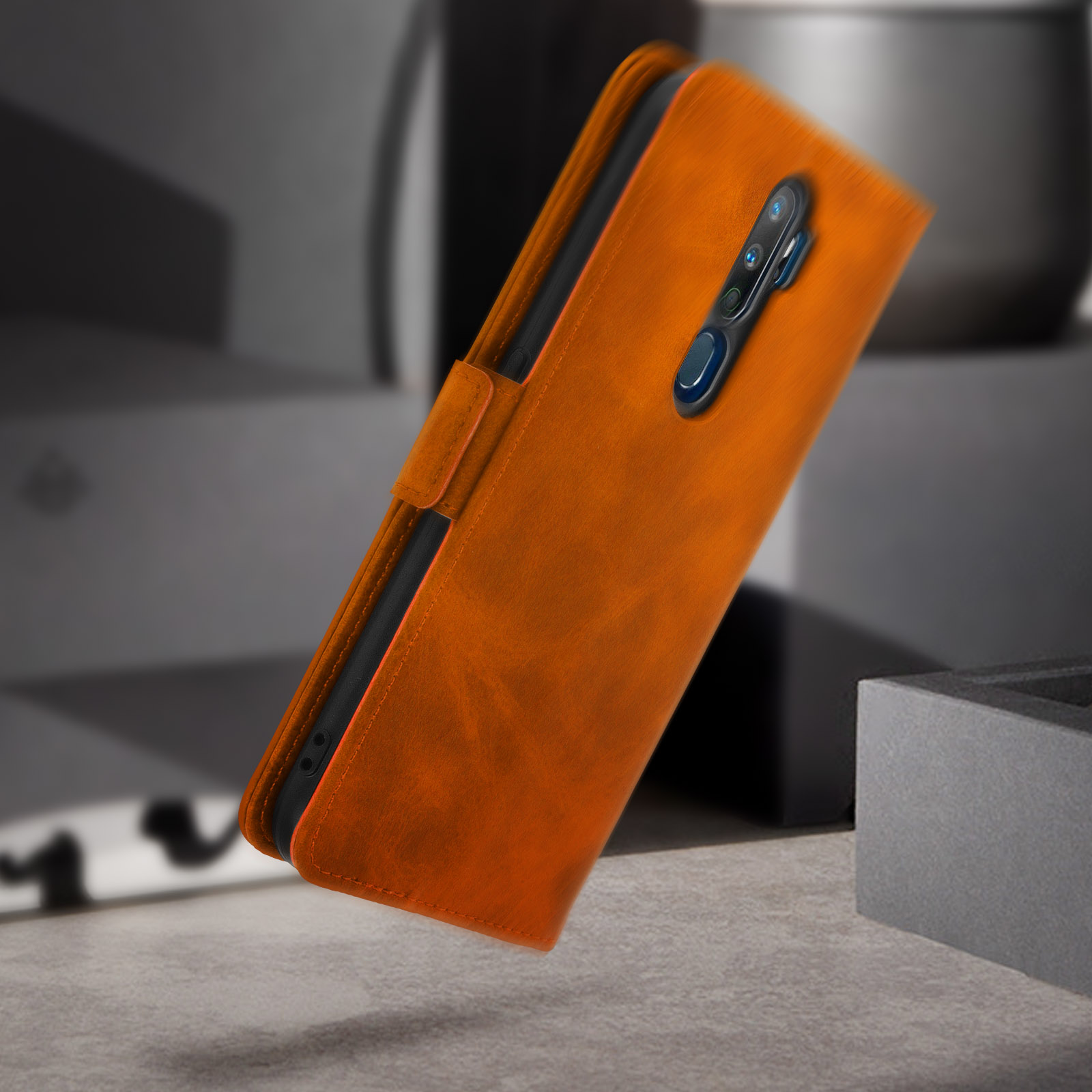 Een oranje leren telefoonhoesje. De hoes heeft een flap die sluit met een magnetische sluiting.