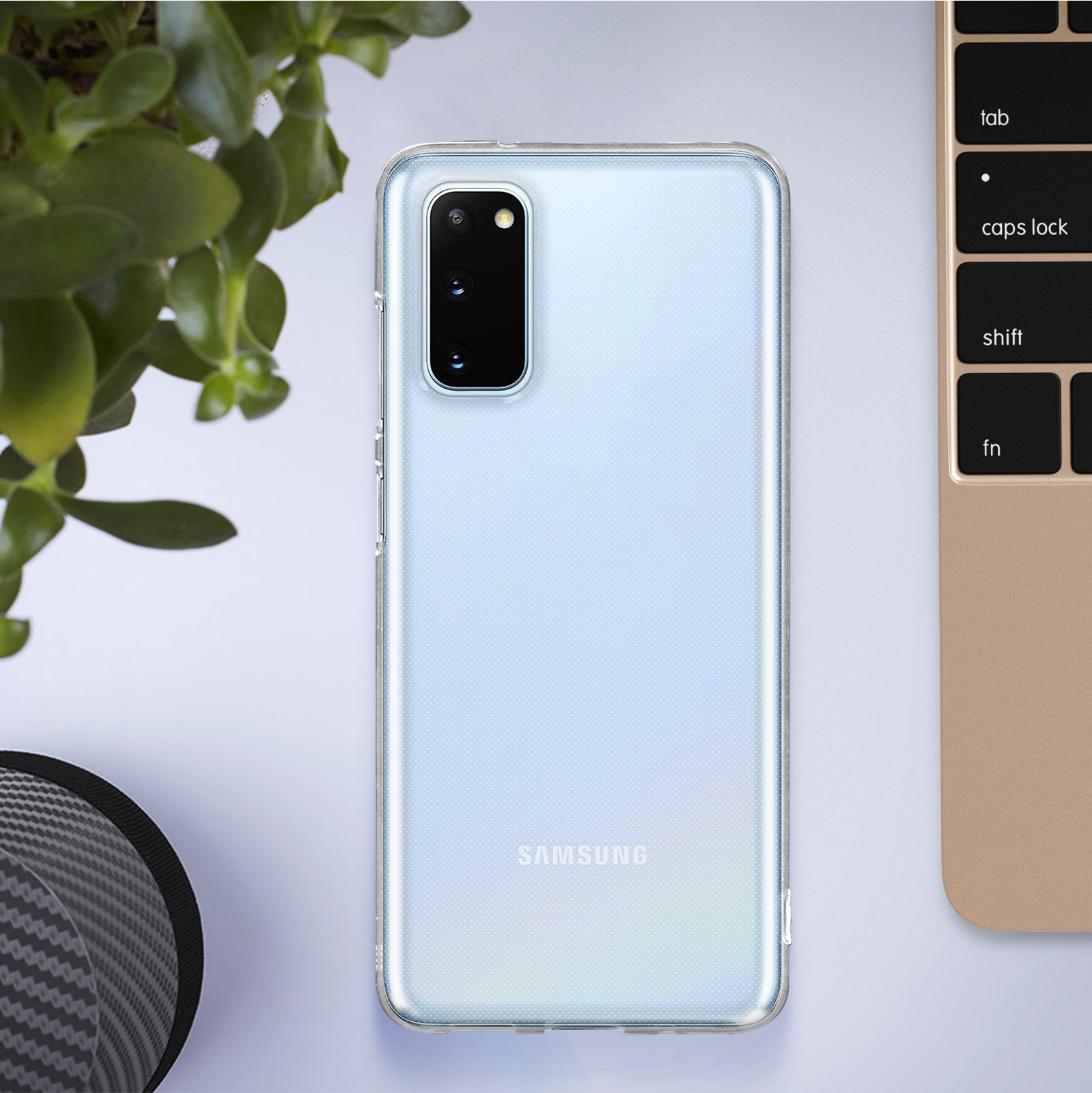 Une coque de téléphone transparente sur une table, à côté d'une plante et d'un clavier.