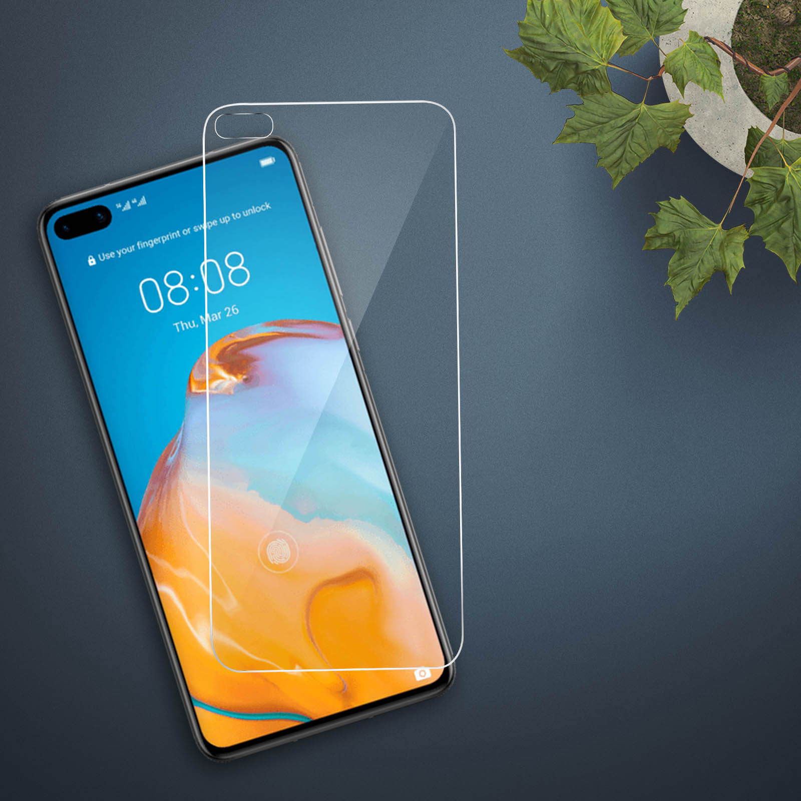 Telefono con protezione schermo. Il telefono è su una superficie scura. Piante verdi sullo sfondo.