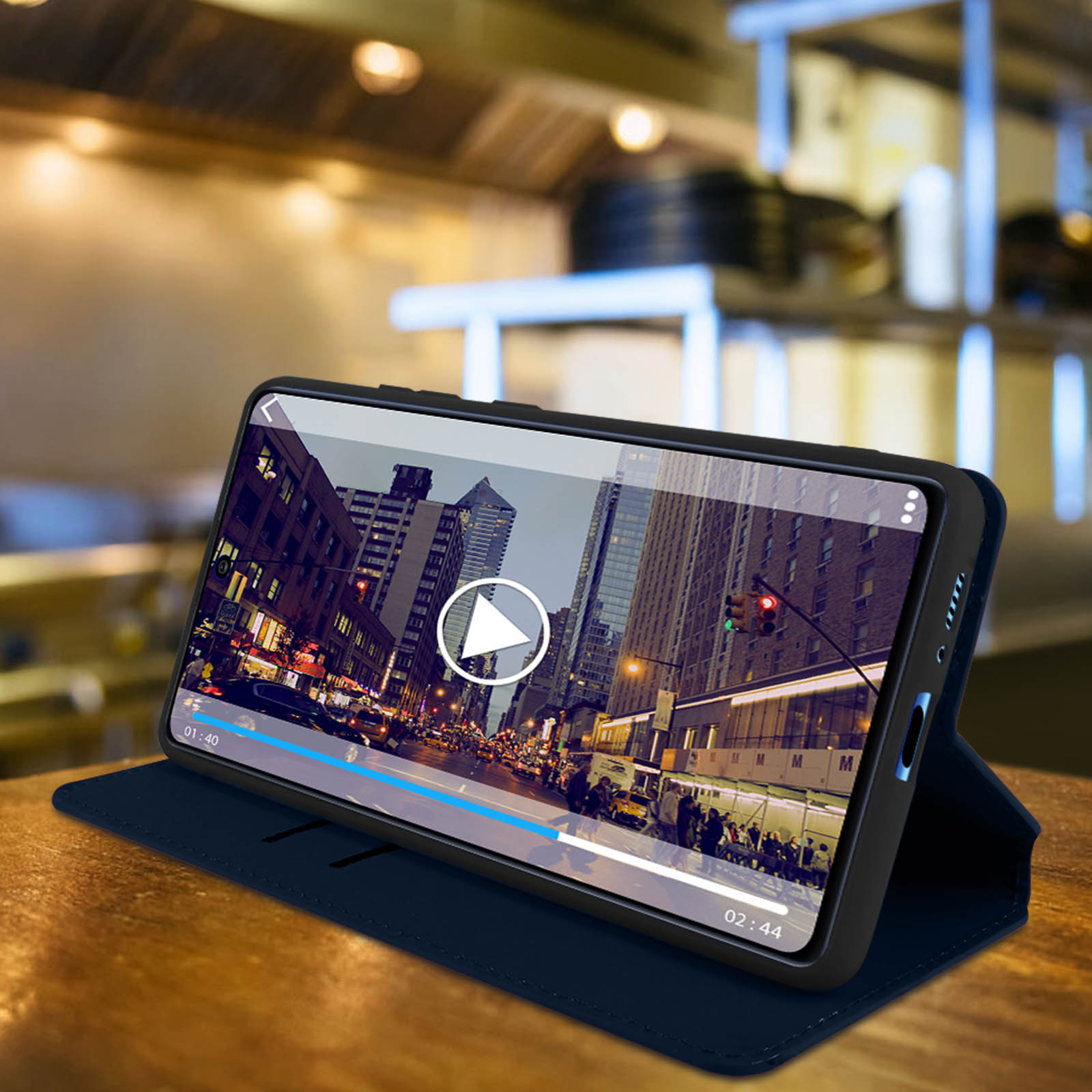 Telefono in custodia, riproduce video di una città, su custodia blu, con scena bar, durata video.