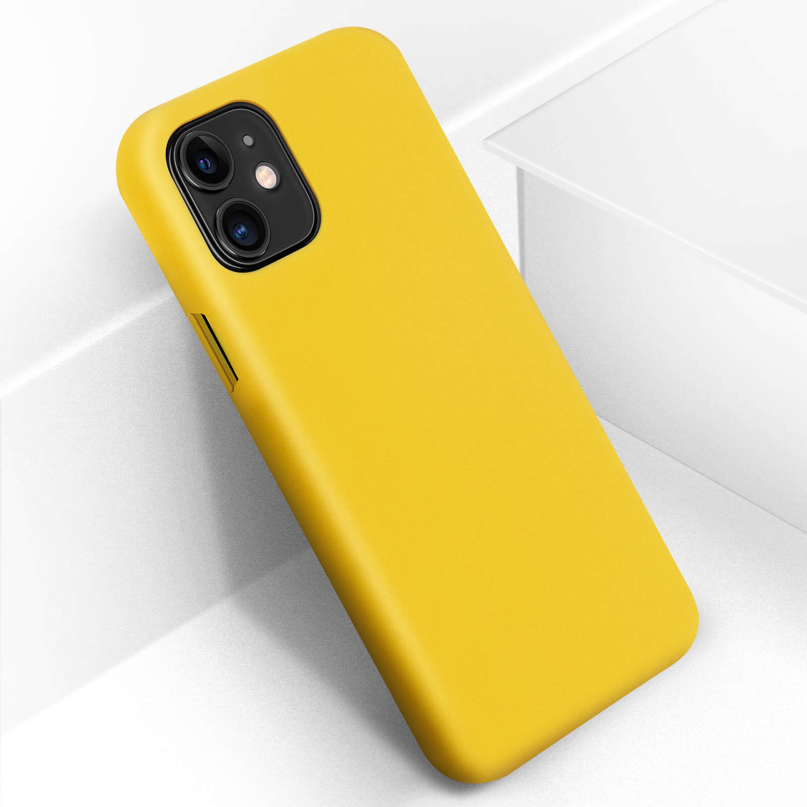 Une coque de téléphone jaune avec un téléphone à l'intérieur, en angle sur une surface blanche avec un fond blanc.